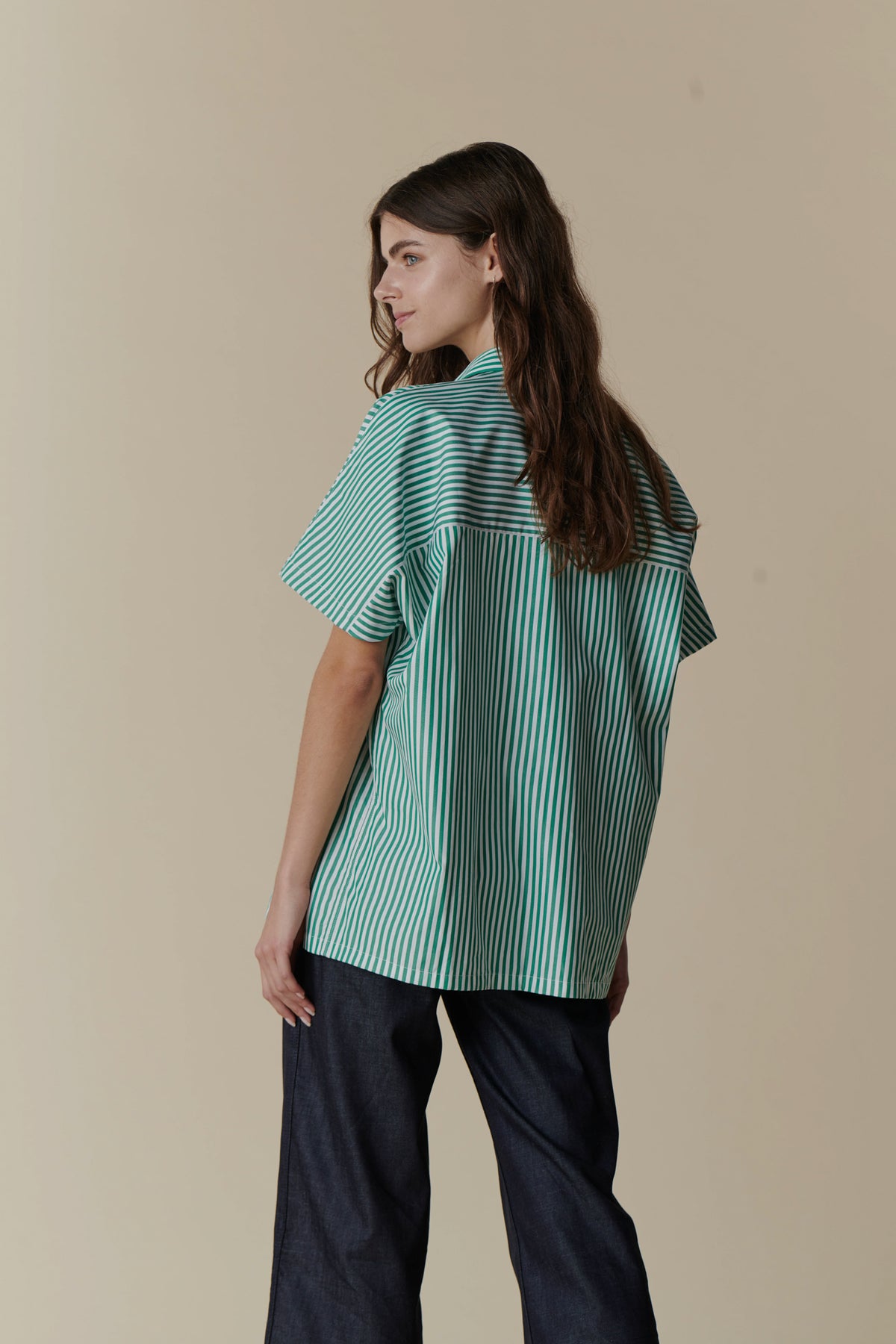 woman wearing oversized green and white short sleeved shirt with wide leg trousers
