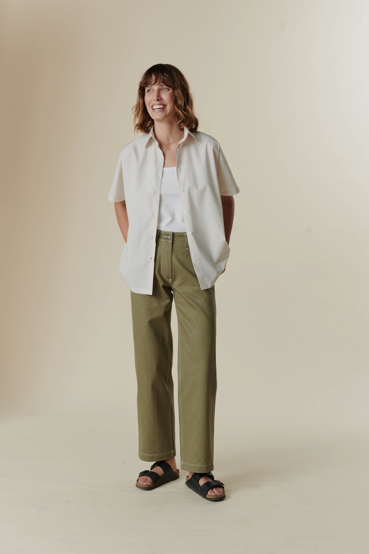 Woman smiling whilst wearing the Ava shirt and olive work jean