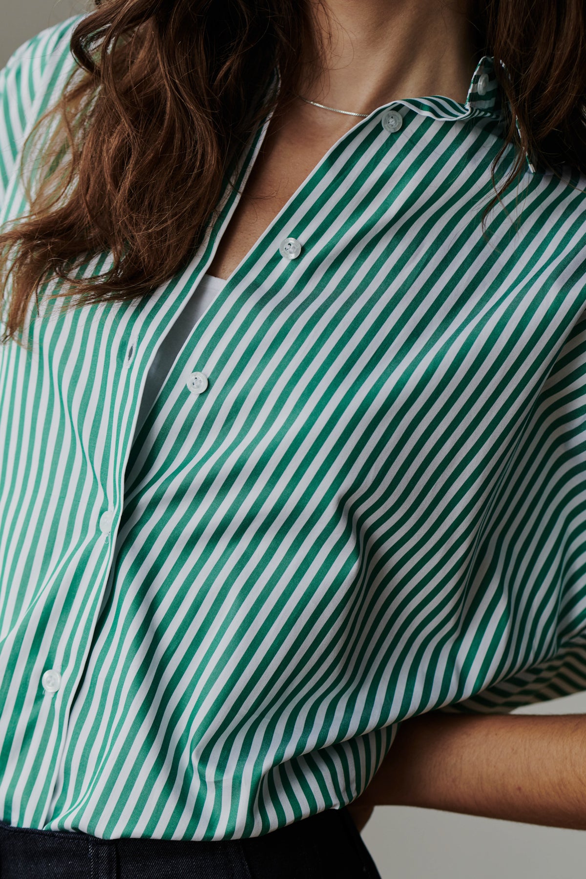 close up detail shot of unbuttoned green and white striped shirt