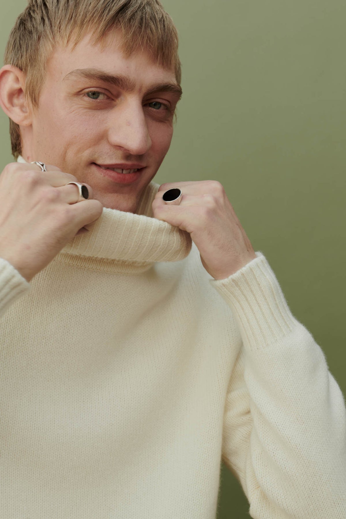 portrait shot of smiley white male wearing lambswool roll neck in ecru