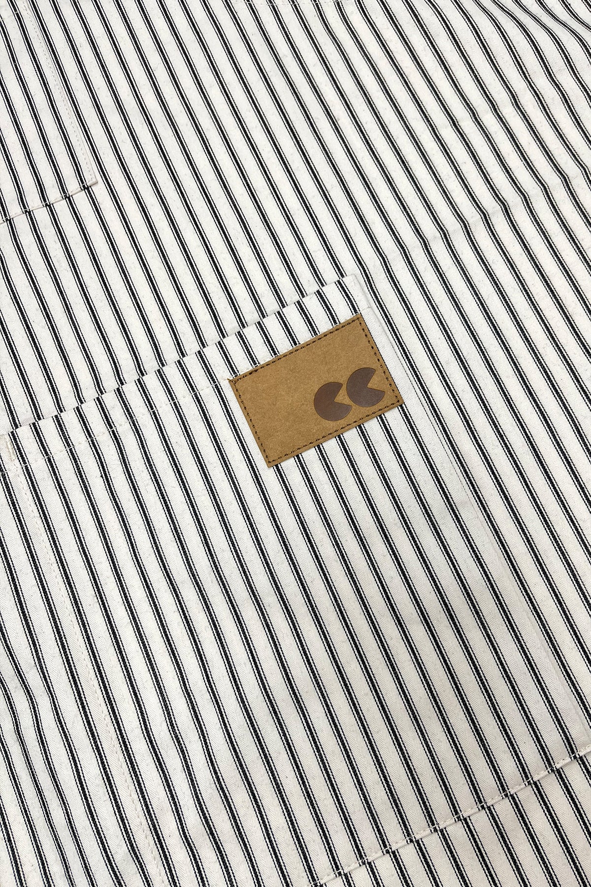 Close up of striped apron with a logo patch