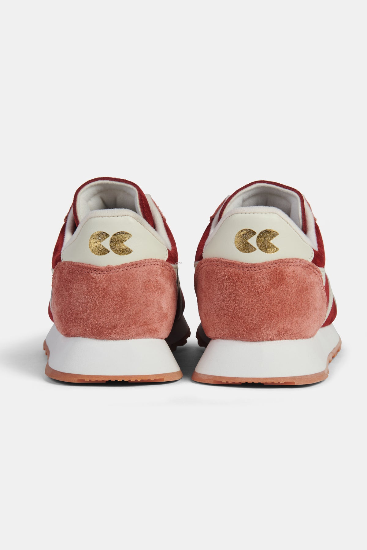 Pair of red and white trainers on a white background.