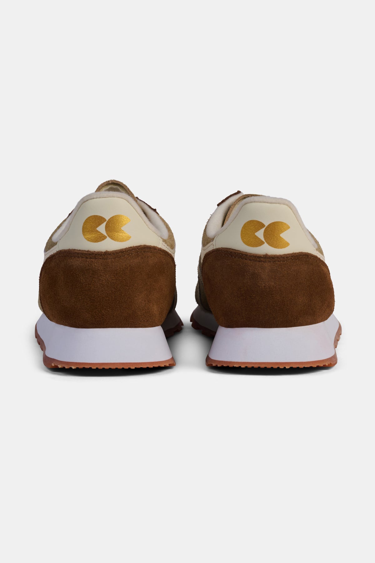 Brown and beige sneakers with a logo on a white background.