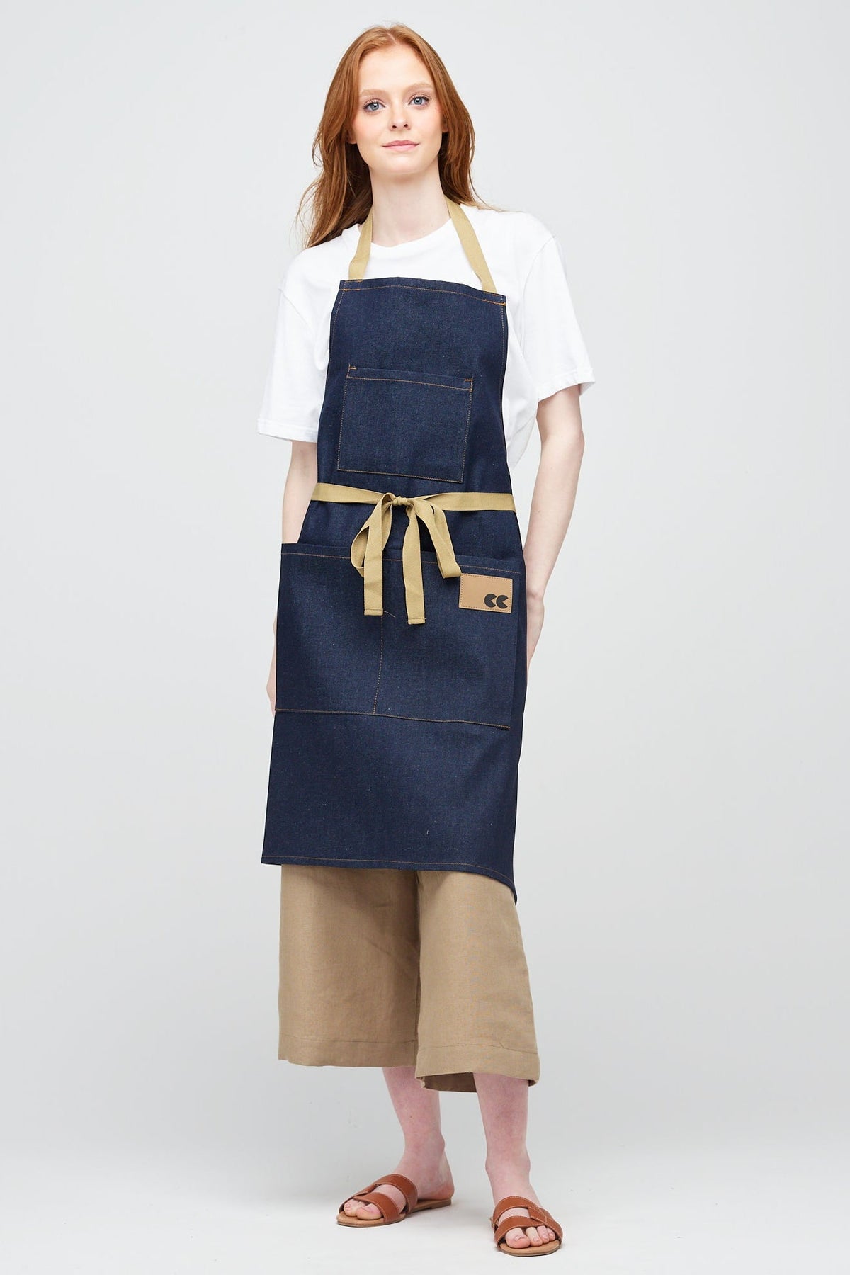 White Female with ginger hair wearing indigo denim apron