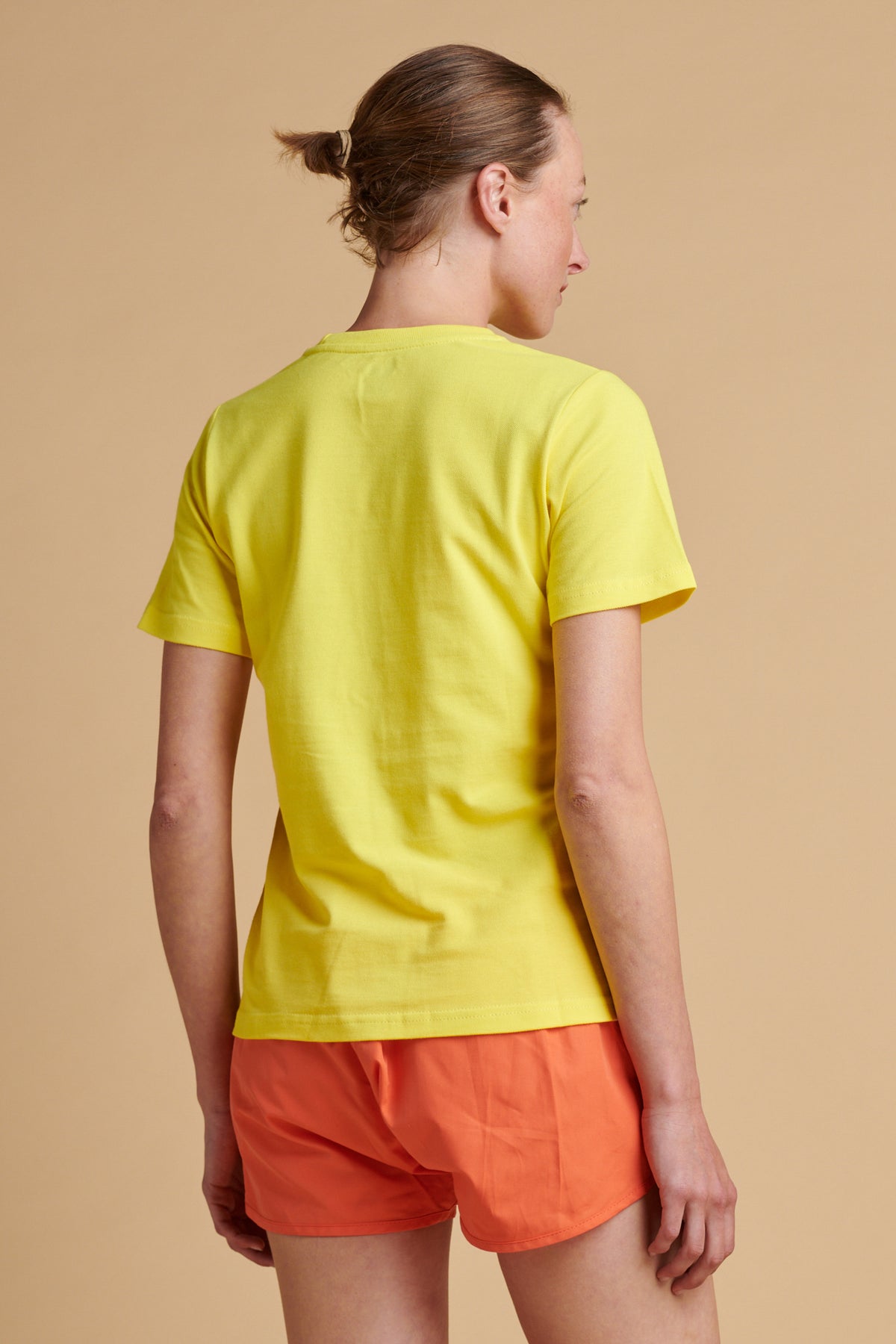 The back of female wearing breathable t shirt in canary yellow.