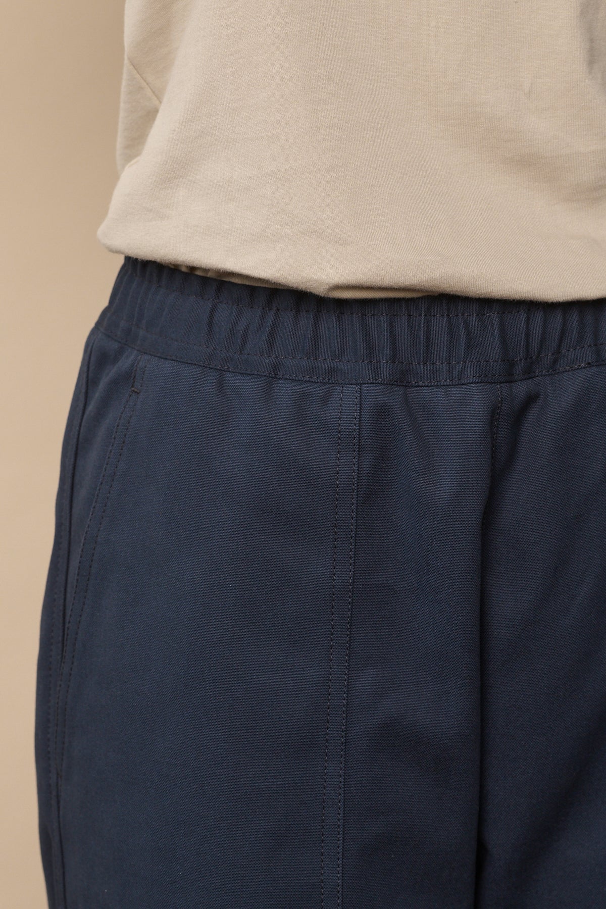 Drawstring waistband and front pocket detail of camerawoman trousers