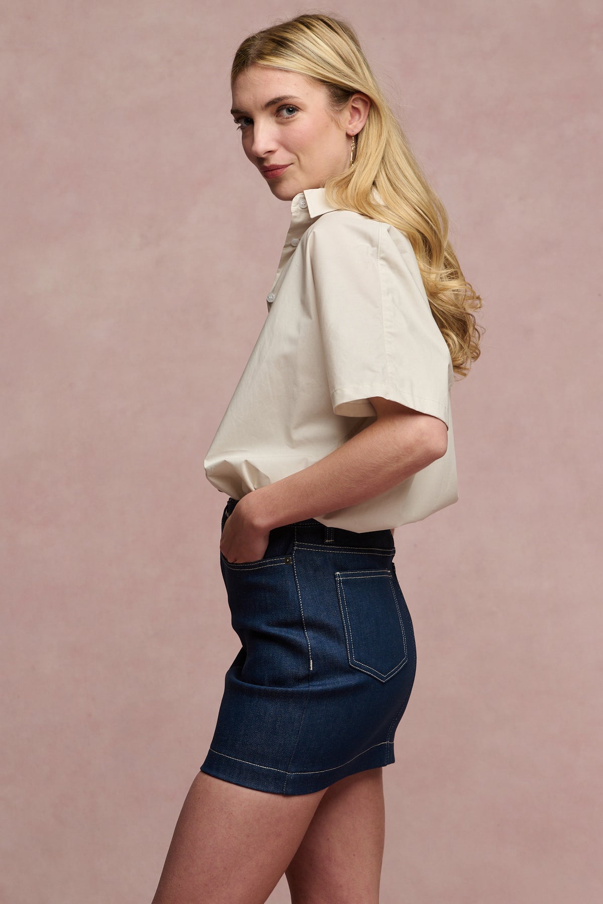 The side of female wearing Charlie denim mini skirt in blue with stone Ava shirt