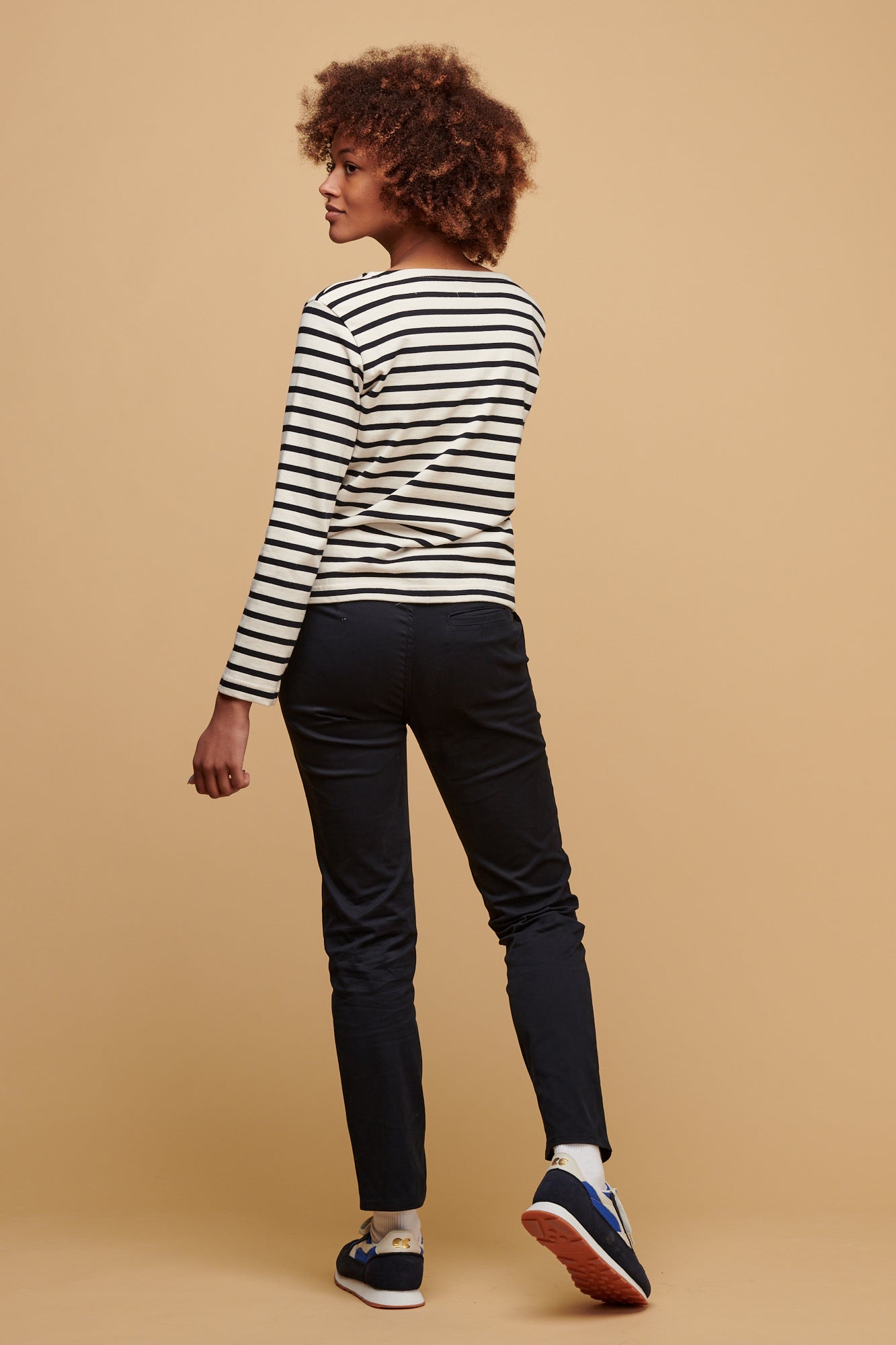 Smiley, black female with afro wearing women's slim stretch chino in navy paired with ecru navy stripe Breton