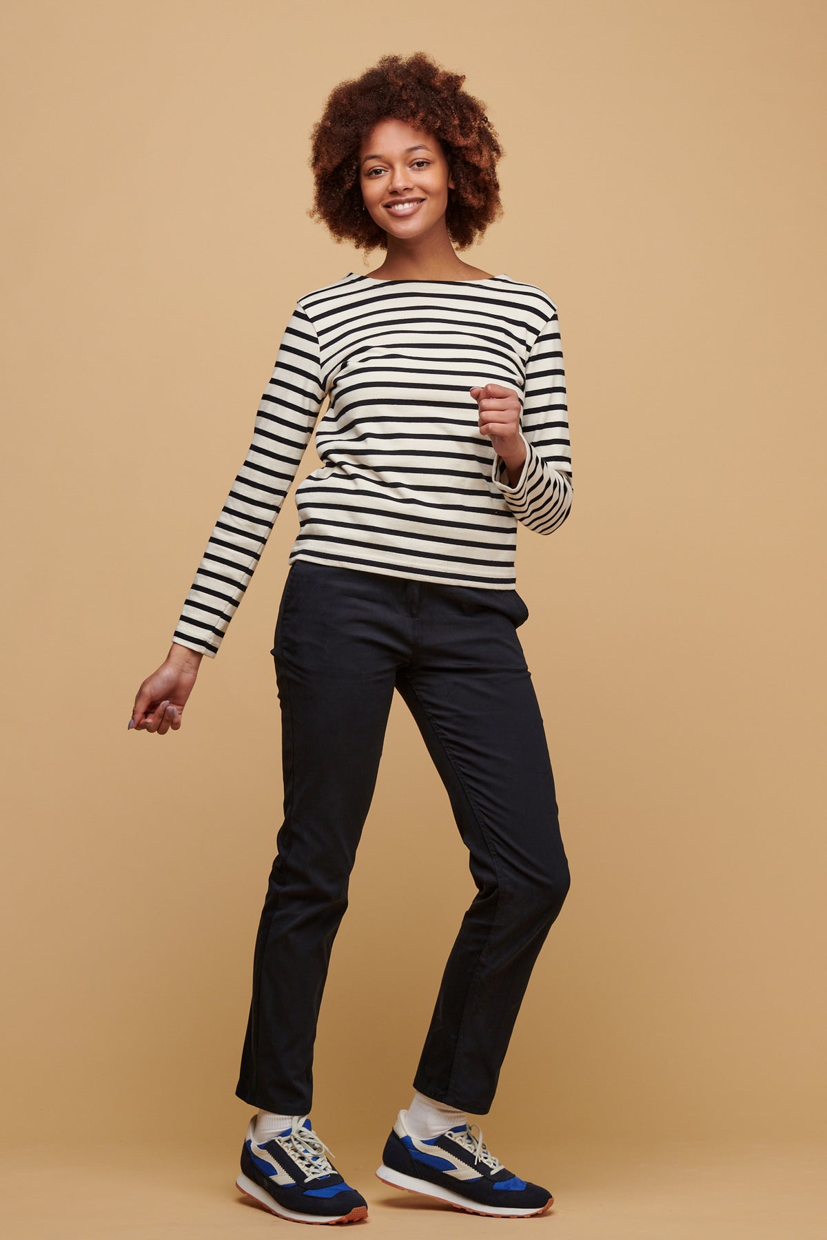 Smiley, black female with afro wearing women's slim stretch chino in navy paired with ecru navy stripe Breton