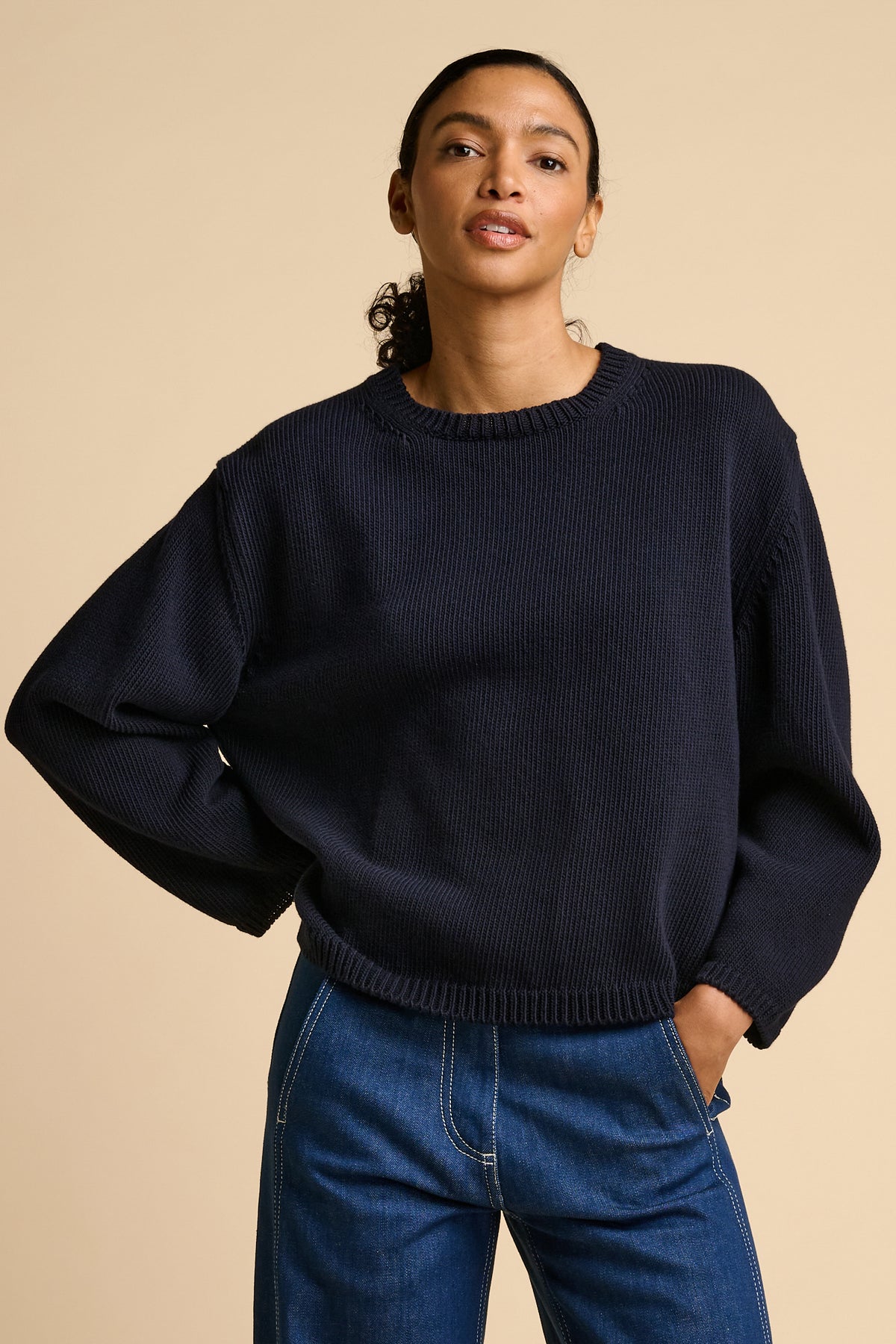 Woman wearing navy sweater.