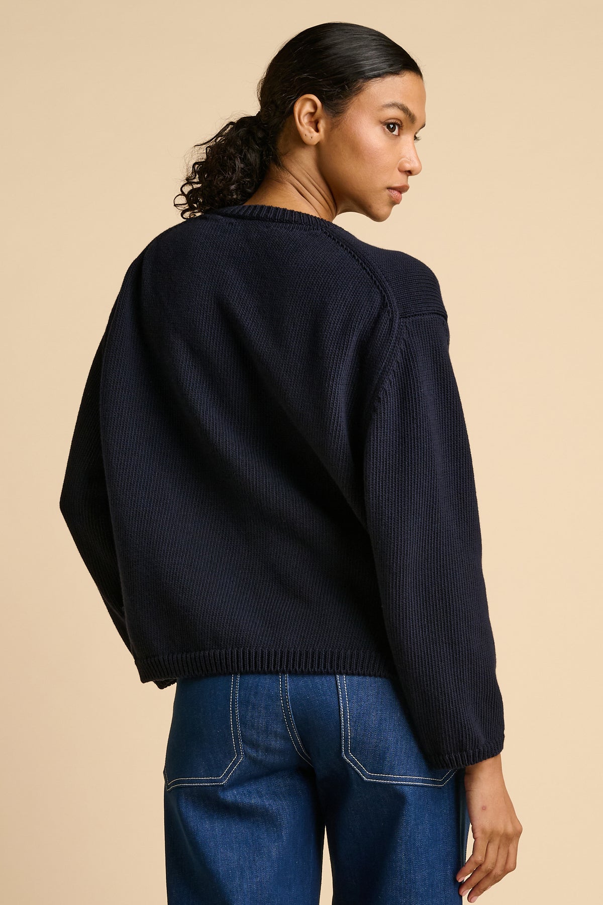 Woman wearing navy sweater.