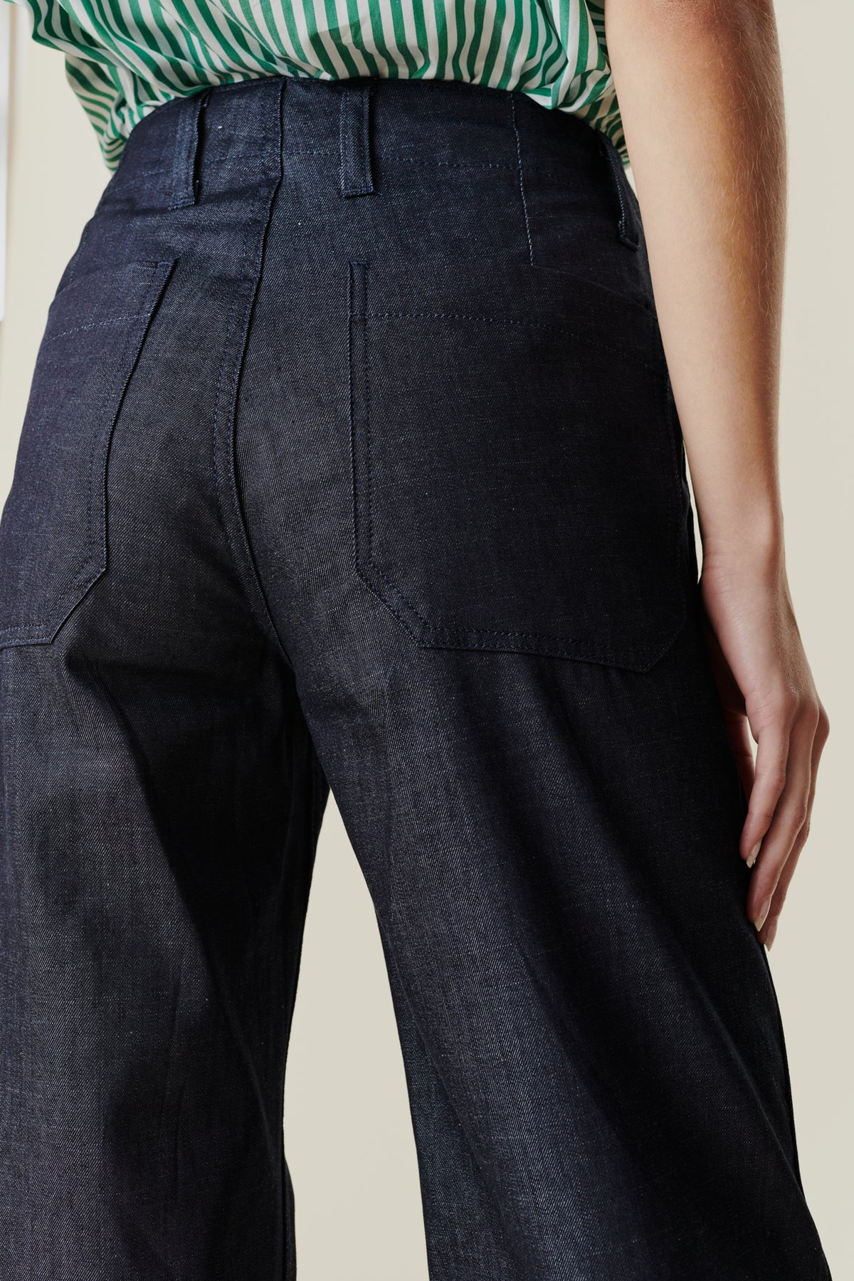 back pocket and belt loop detail of cropped work trousers on female model