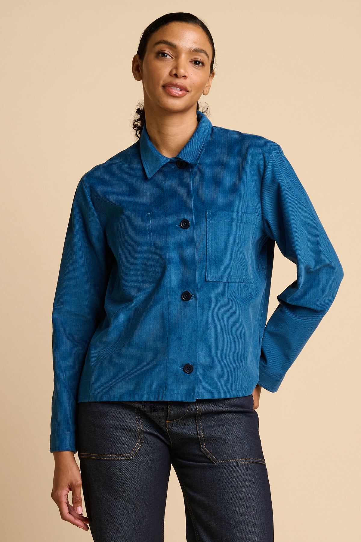 Woman wearing a blue jacket on a beige background