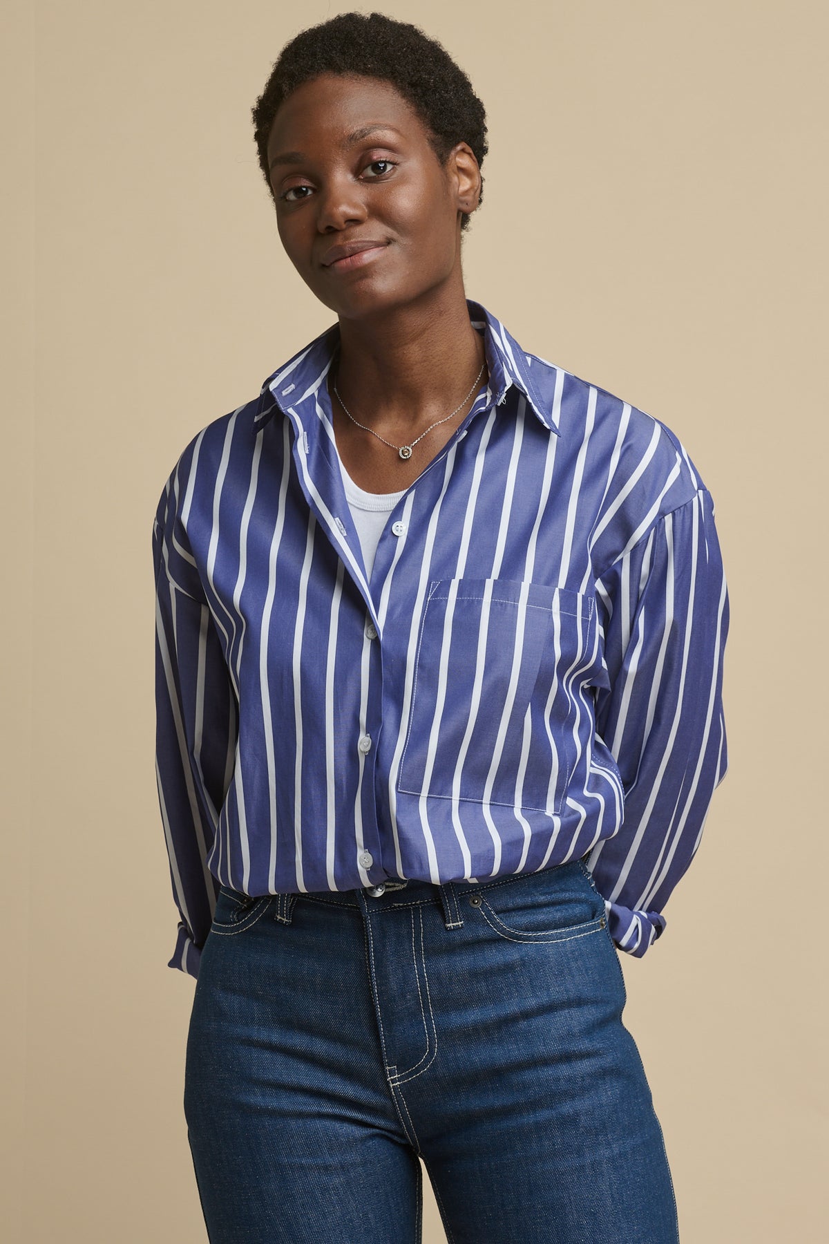 Female wearing long sleeve Esme shirt in blue and white worn buttoned up tucked into blue jeans