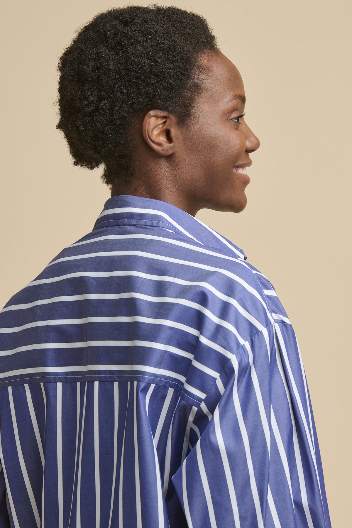 Close up of the back of female wearing Esme long sleeve shirt in blue and white stripe