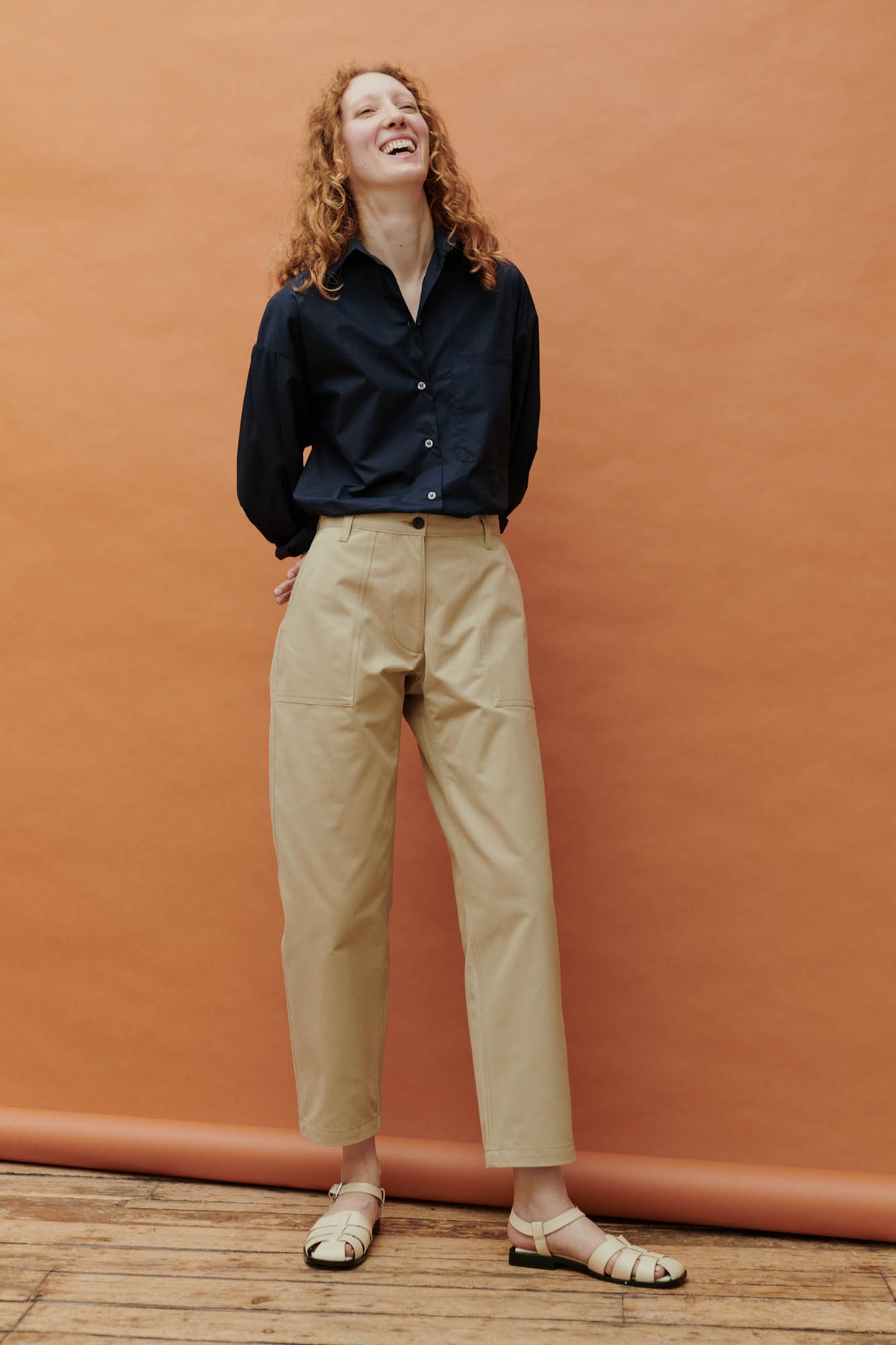 Full body editorial shot of a female wearing the Esme Long Sleeve Shirt with the combat trouser in putty.