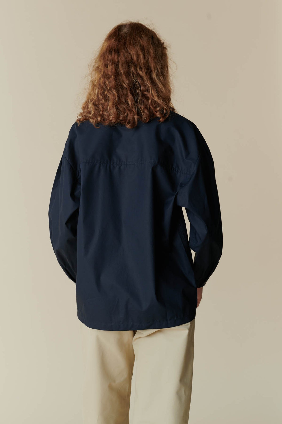 behind view of female wearing esme long sleeve shirt navy and the combat pant in putty
