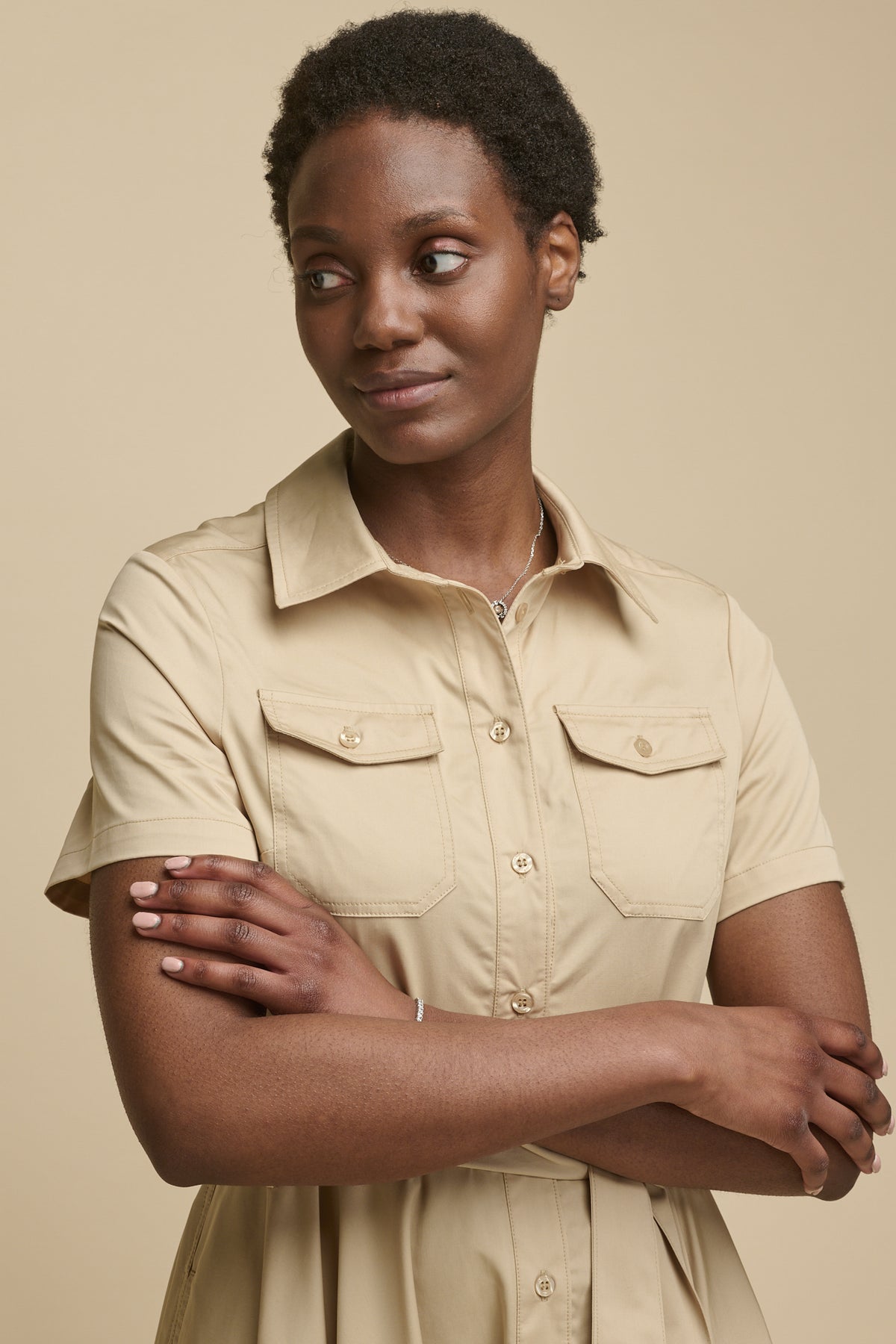 Portrait of female shirt dress in stone with two front chest pockets and short sleeves  