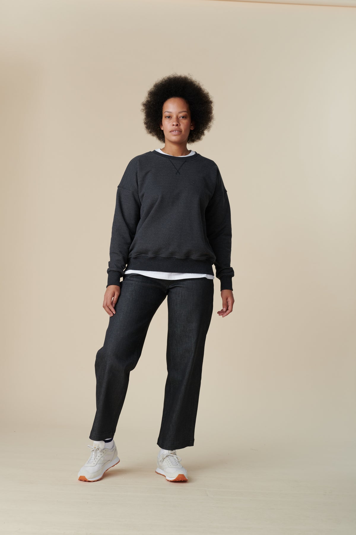 Full body image of female wearing heritage sweatshirt in charcoal