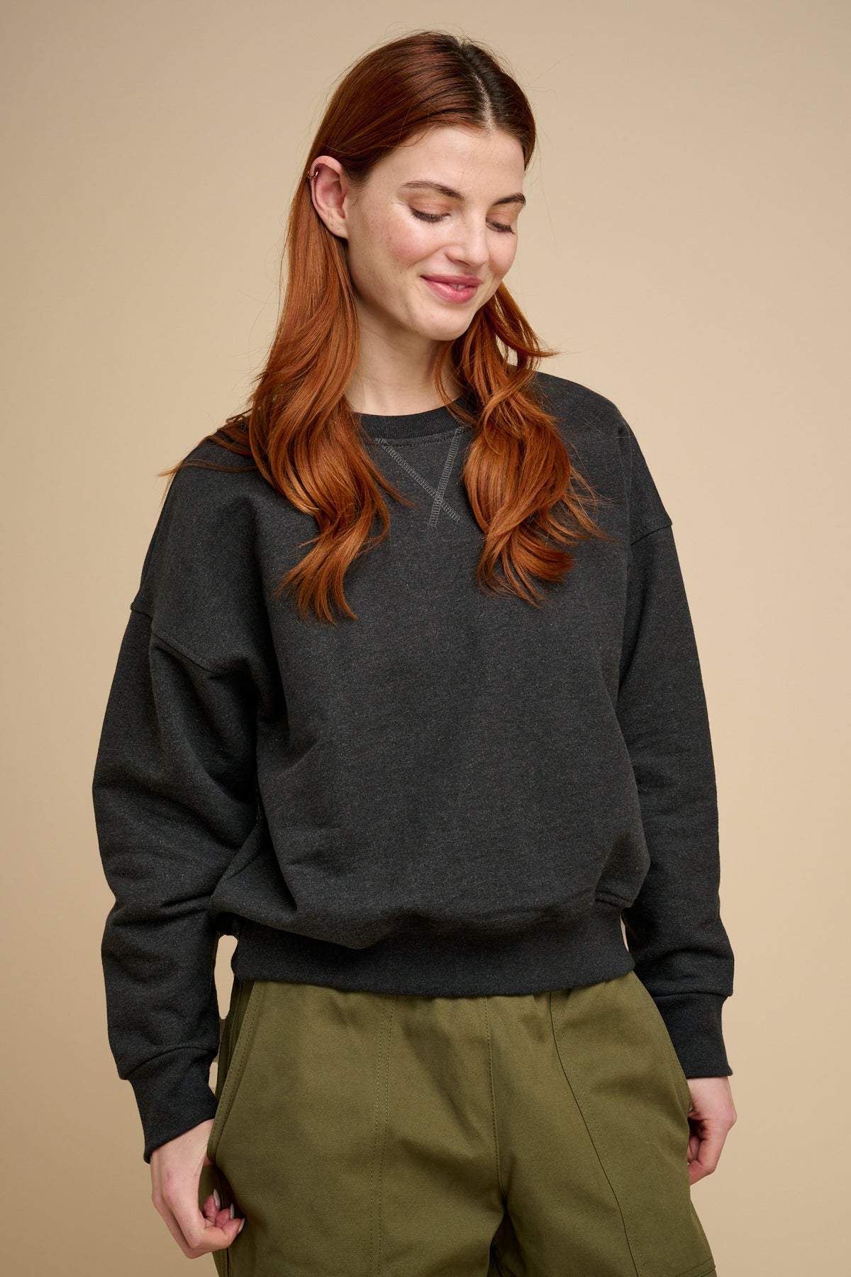 Woman wearing charcoal heavyweight sweatshirt with olive trousers