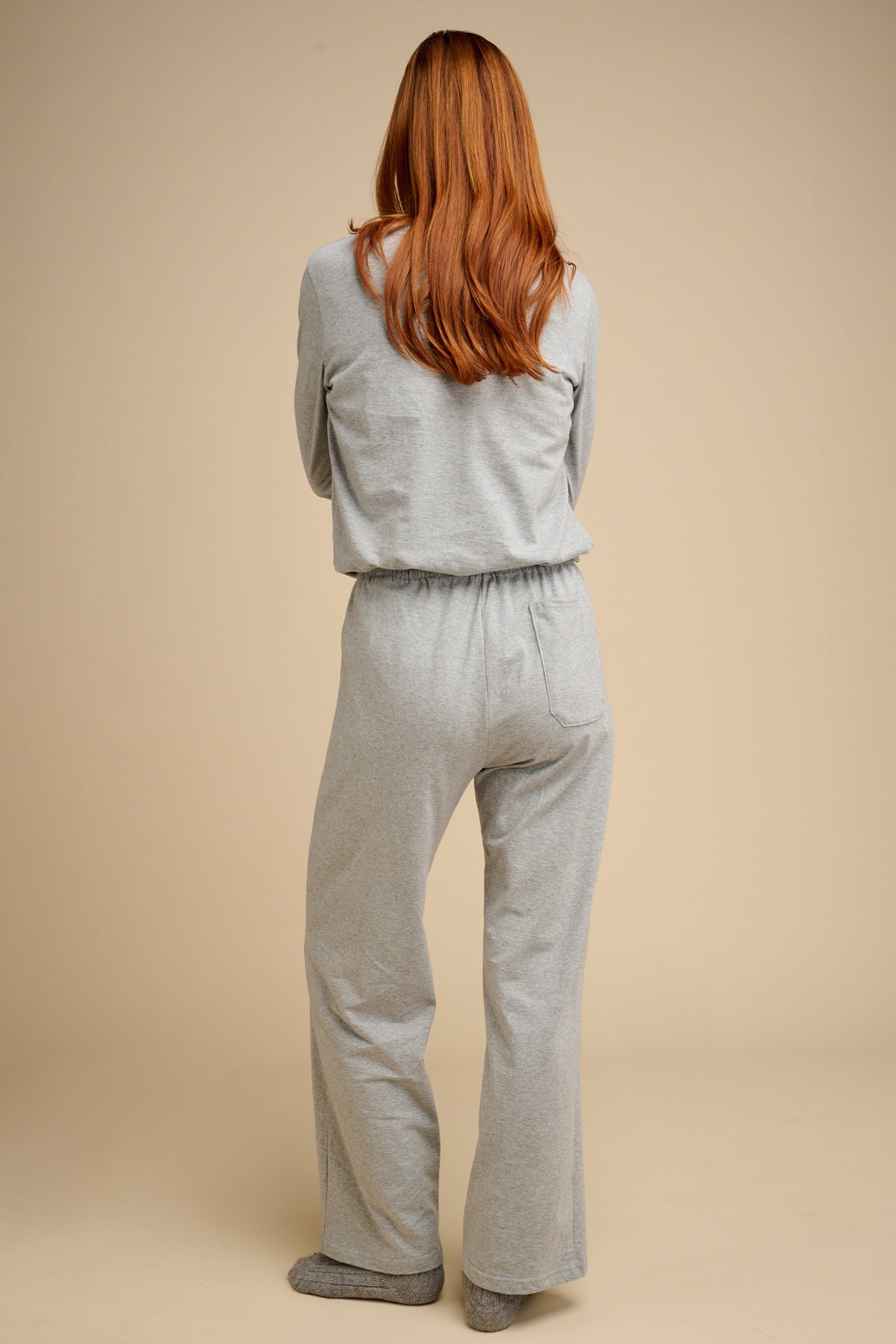 The back of woman wearing grey marl pyjamas.