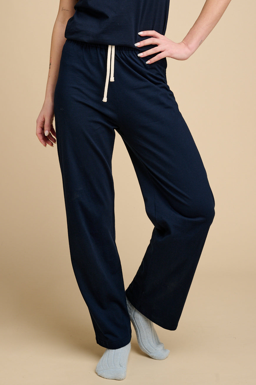 Woman waist down wearing navy pyjama bottoms with matching navy t shirt