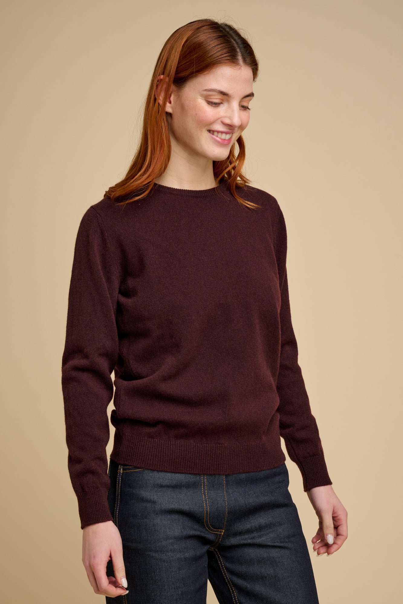 Woman wearing lambswool crew neck jumper in chocolate.
