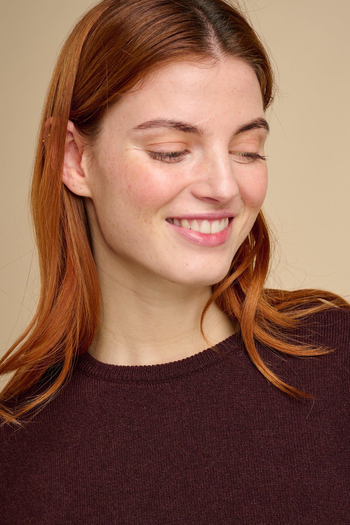 Woman wearing lambswool crew neck jumper in chocolate.