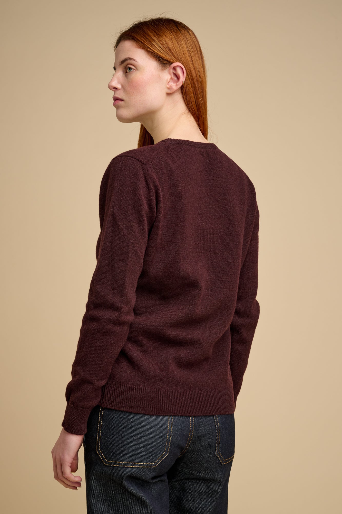 Woman wearing lambswool crew neck jumper in chocolate.