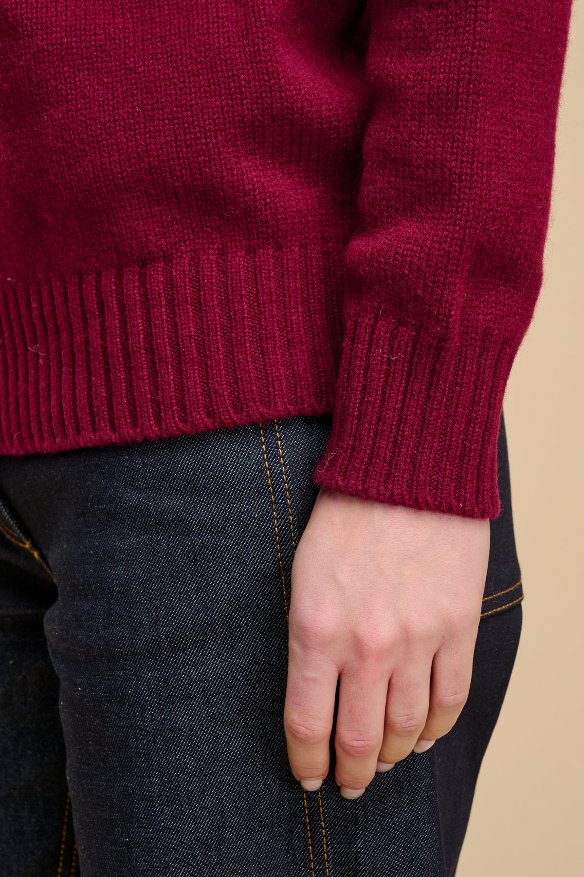 Close up of burgundy jumper ribbed hem and cuff.