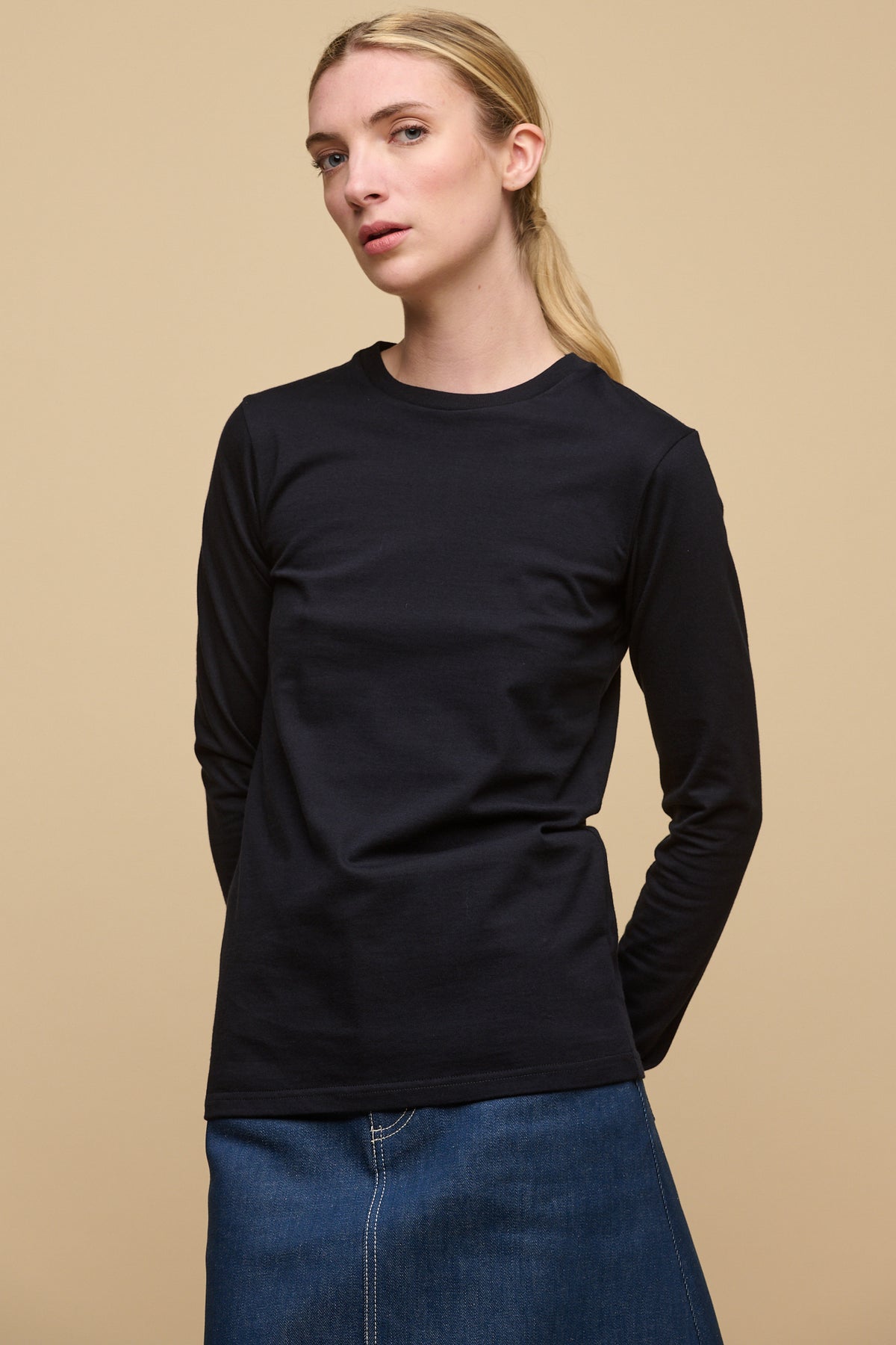 Image of female wearing long sleeve t shirt in navy paired with Bobbie denim midi skirt