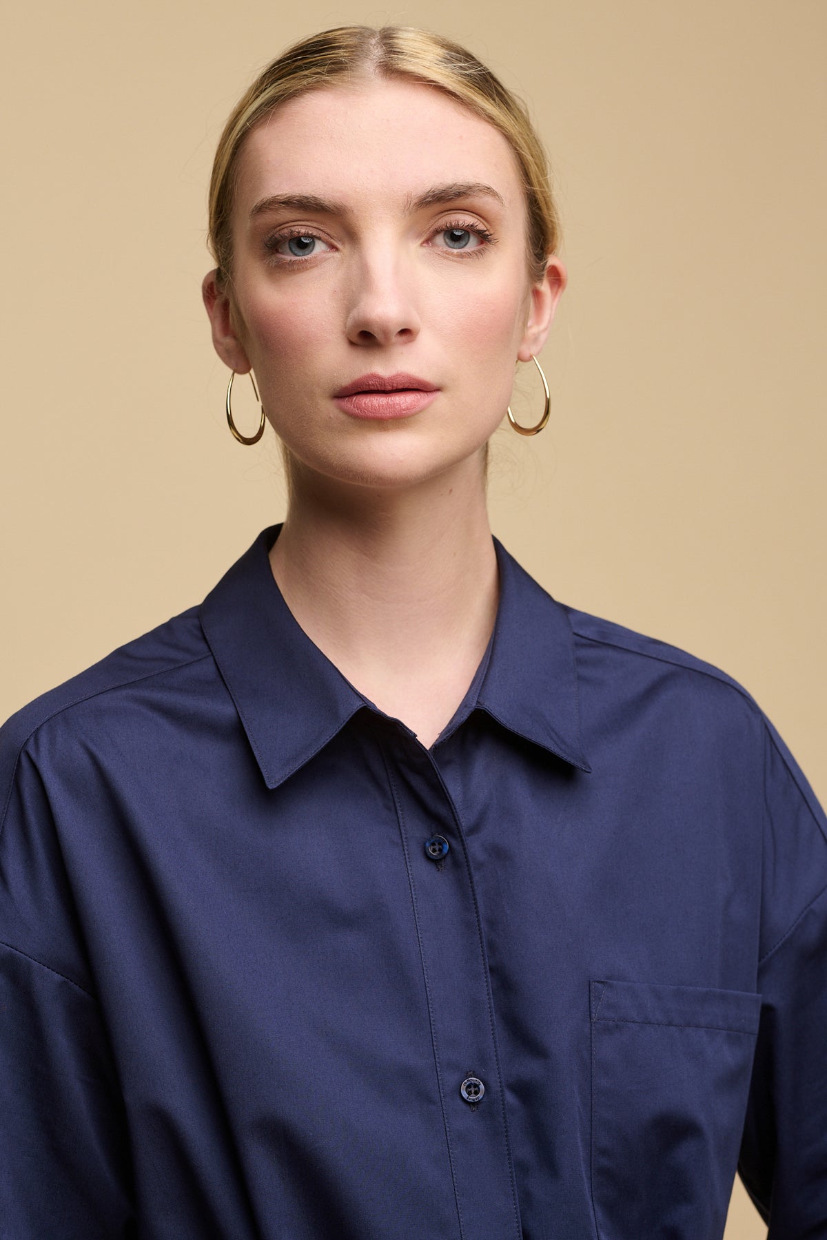 Portrait of female with blonde hair tied back wearing Lorelle belted midi cotton shirt dress navy 