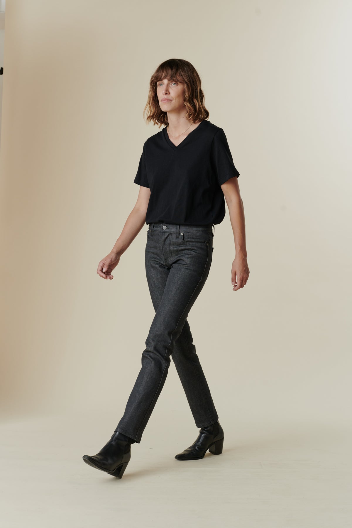 Full body image of female wearing mid rise straight leg jeans in black