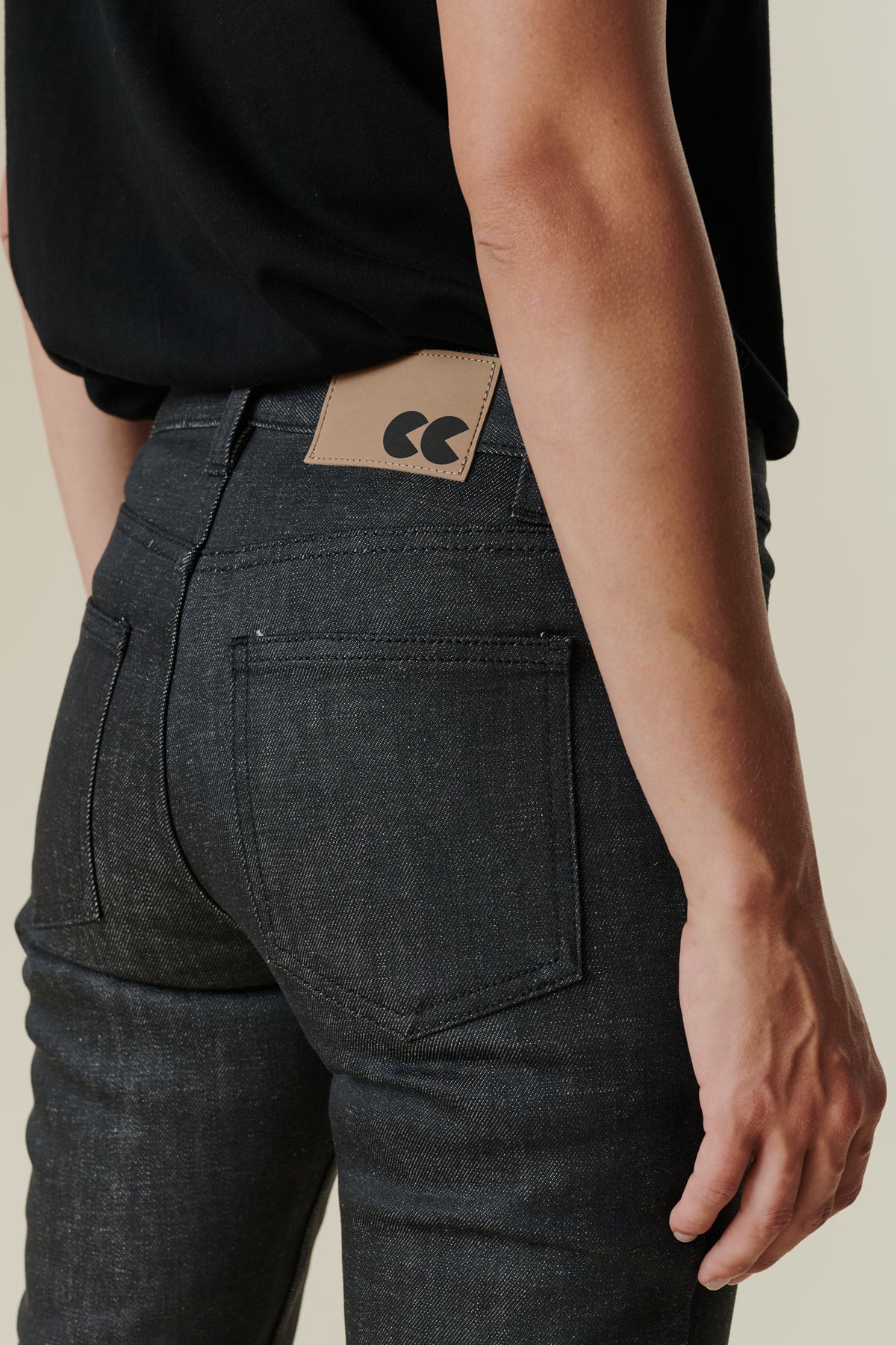 Back pocket detail image of female  wearing mid rise straight leg jeans in black