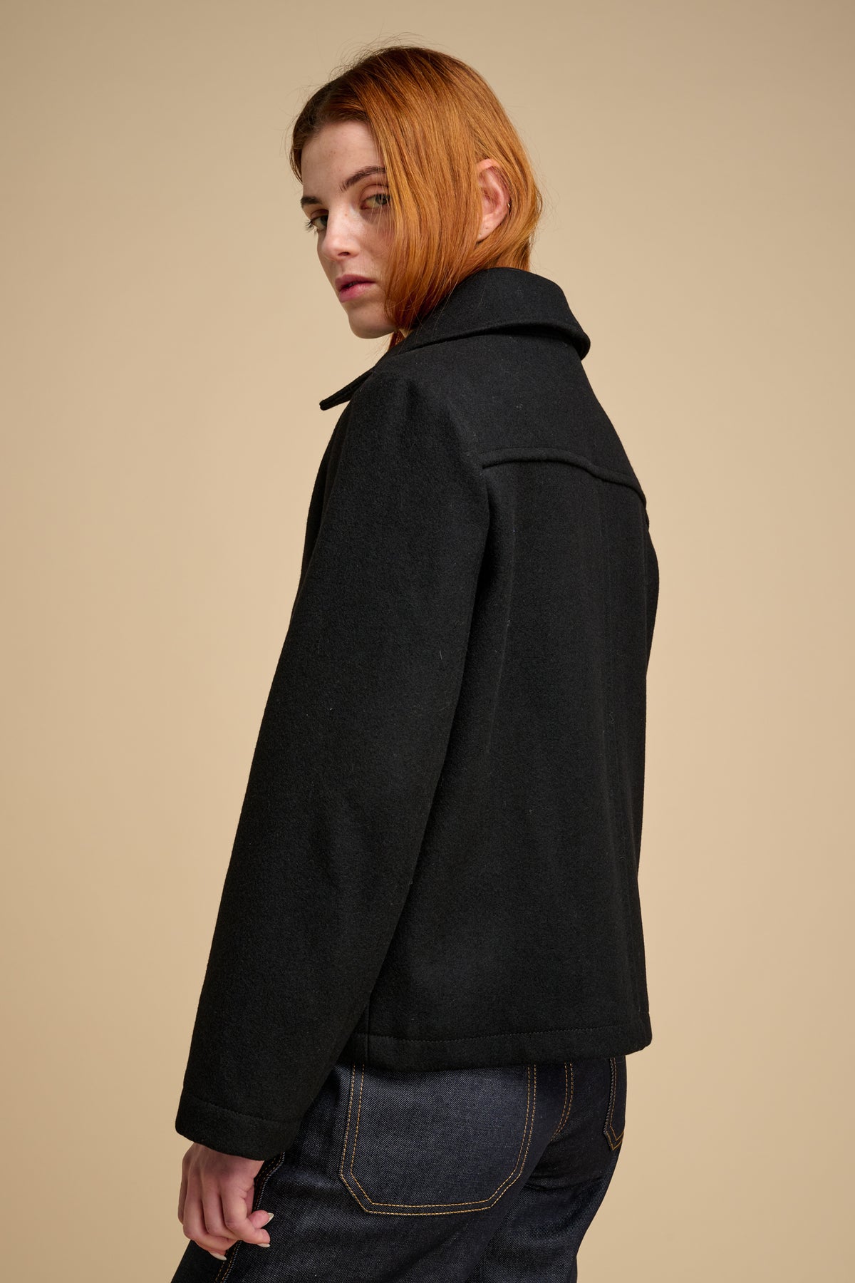 The back of woman wearing wool jacket in black.