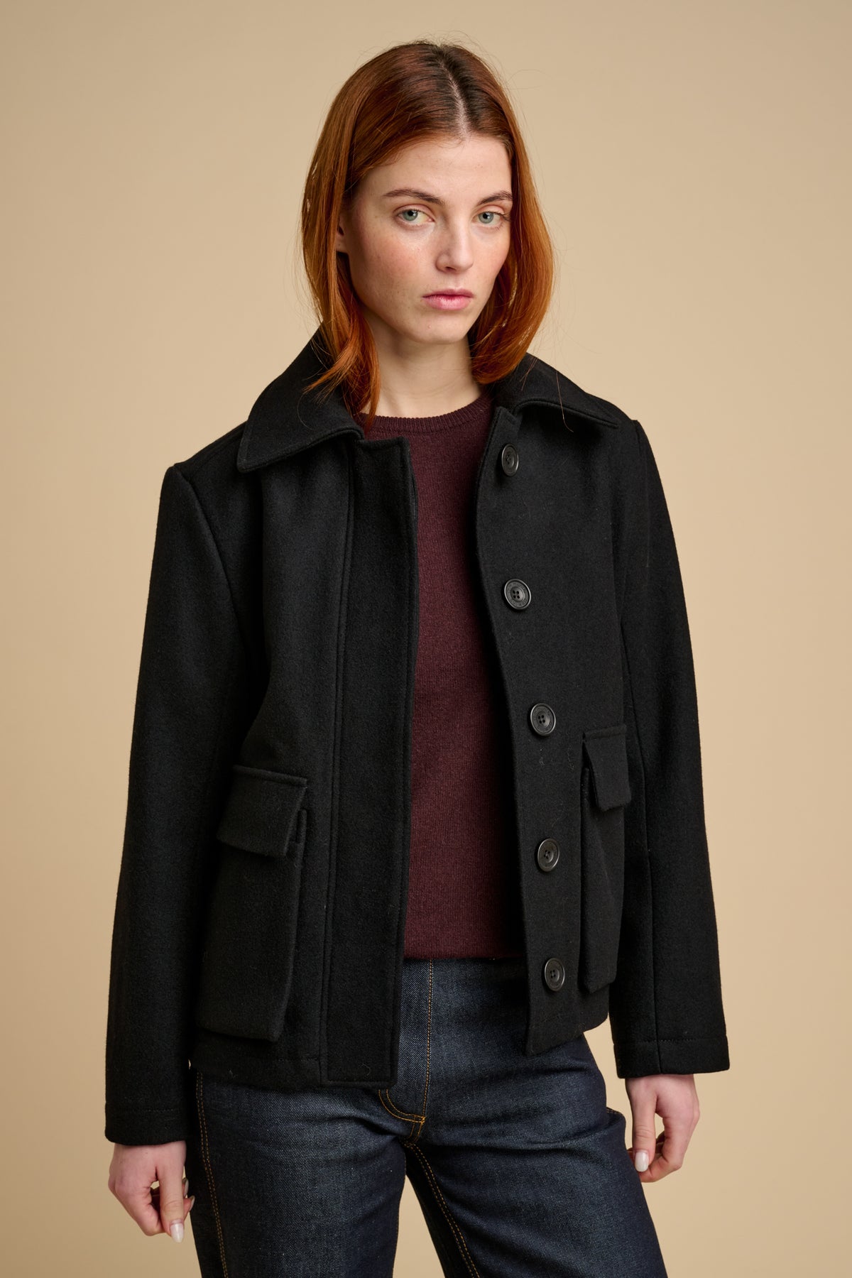 Woman wearing wool jacket in black.
