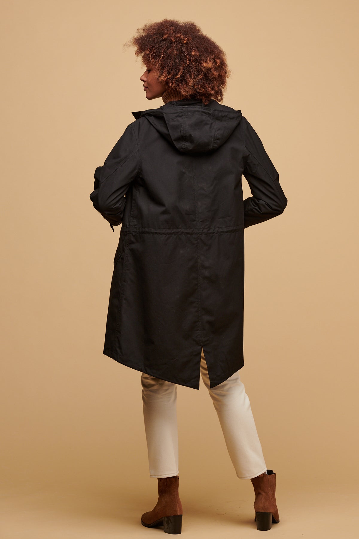 The back of female wearing women's parka coat in black worn with gloria jean in ecru