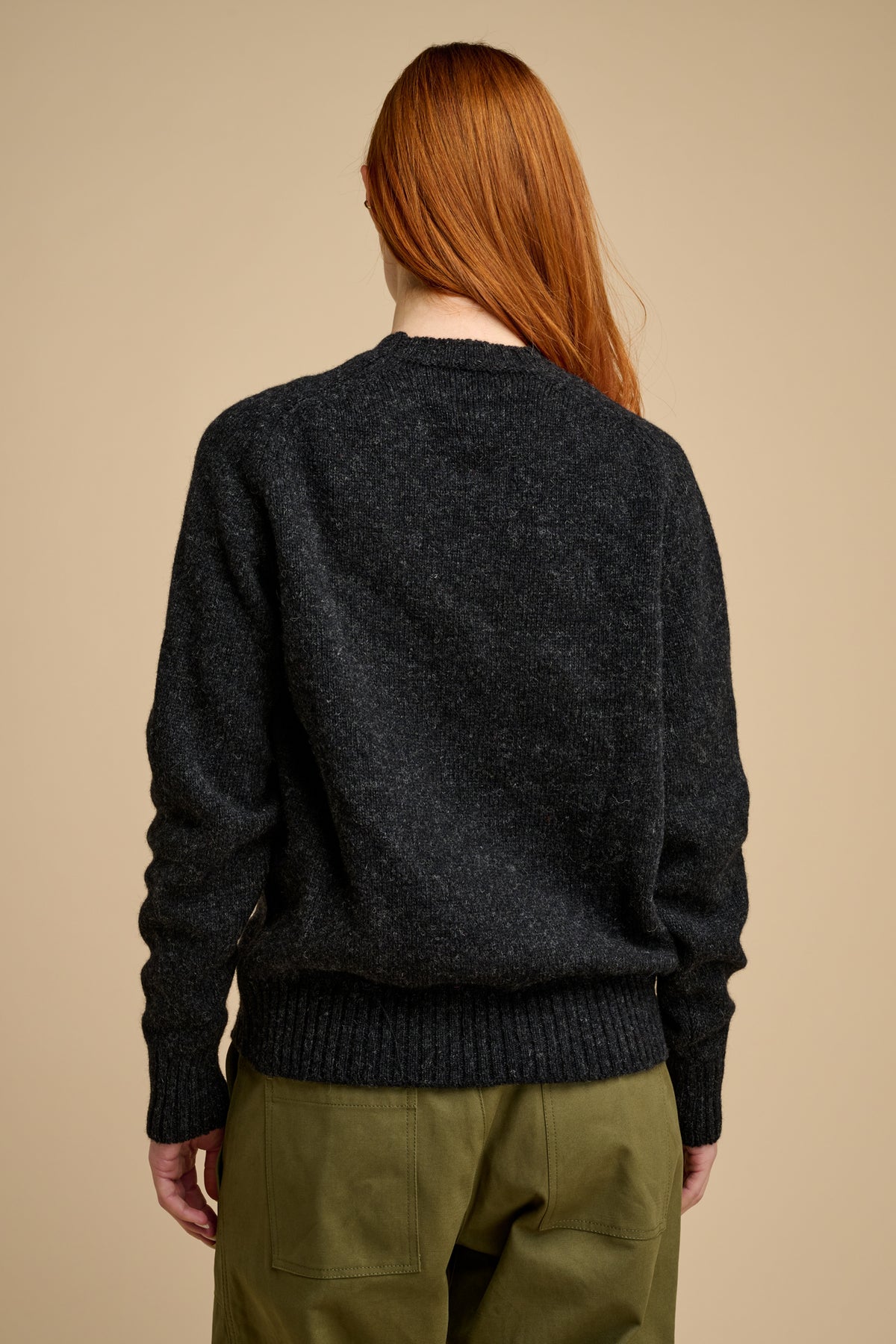 The back of woman wearing shetland knit jumper in charcoal