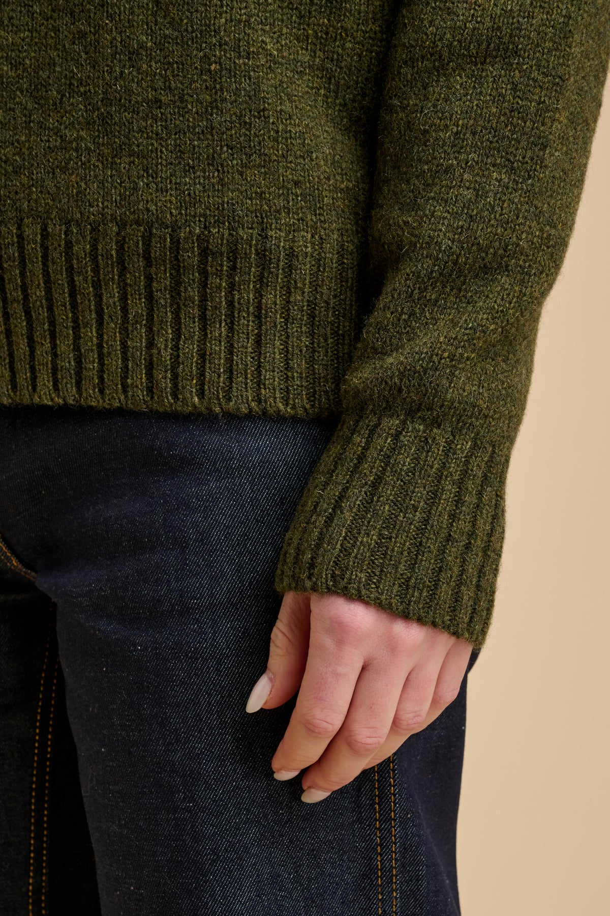Close up of green sweater with ribbed hem and cuff.