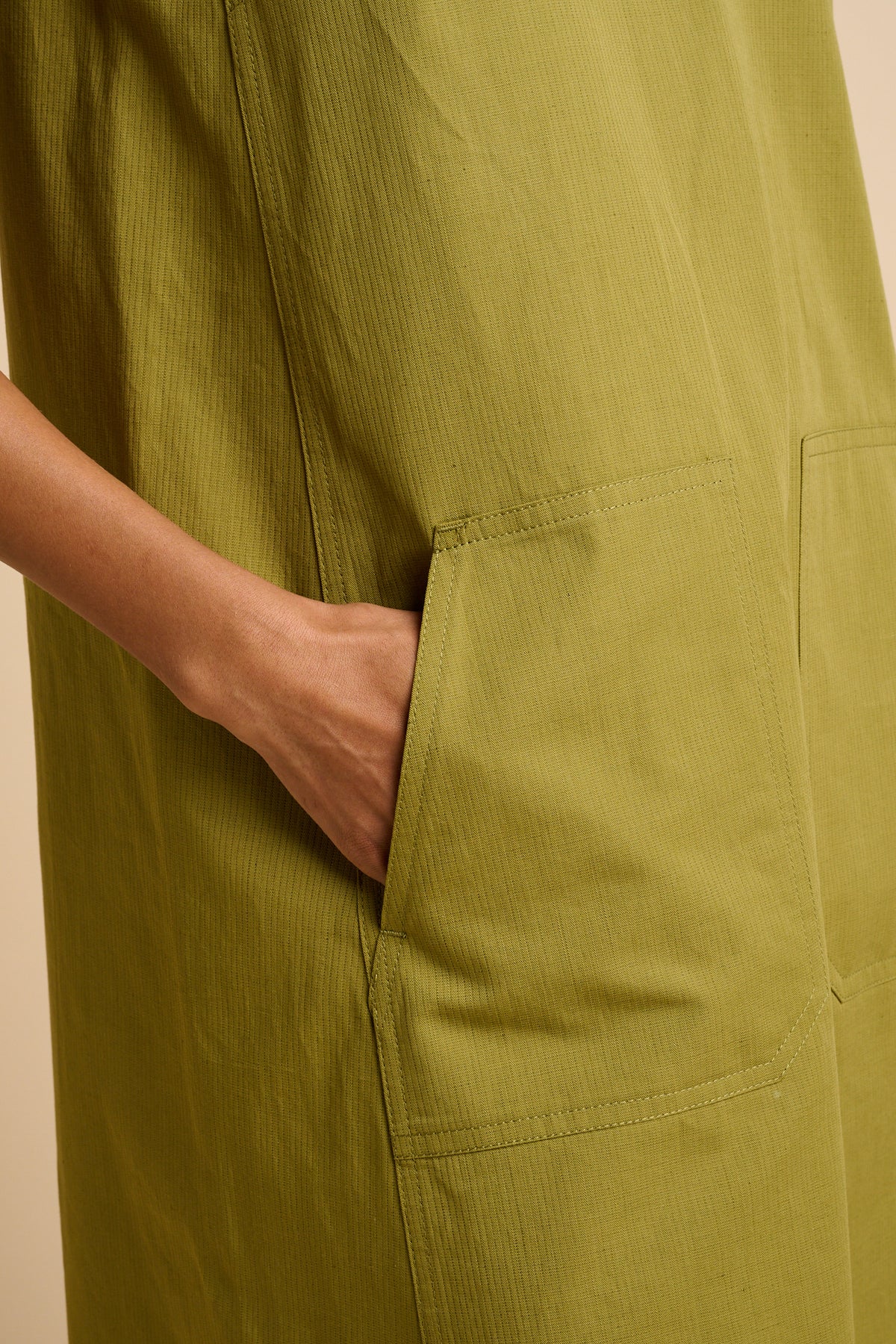 Close up of pocket detail on green dress.