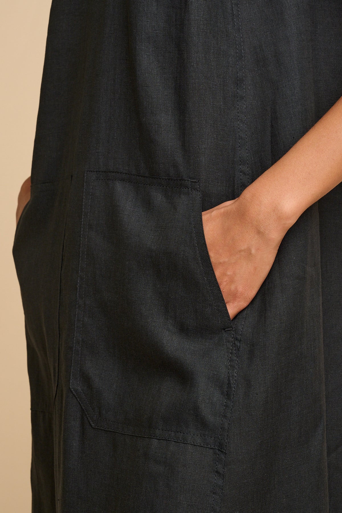 Woman wearing a black dress with pockets.