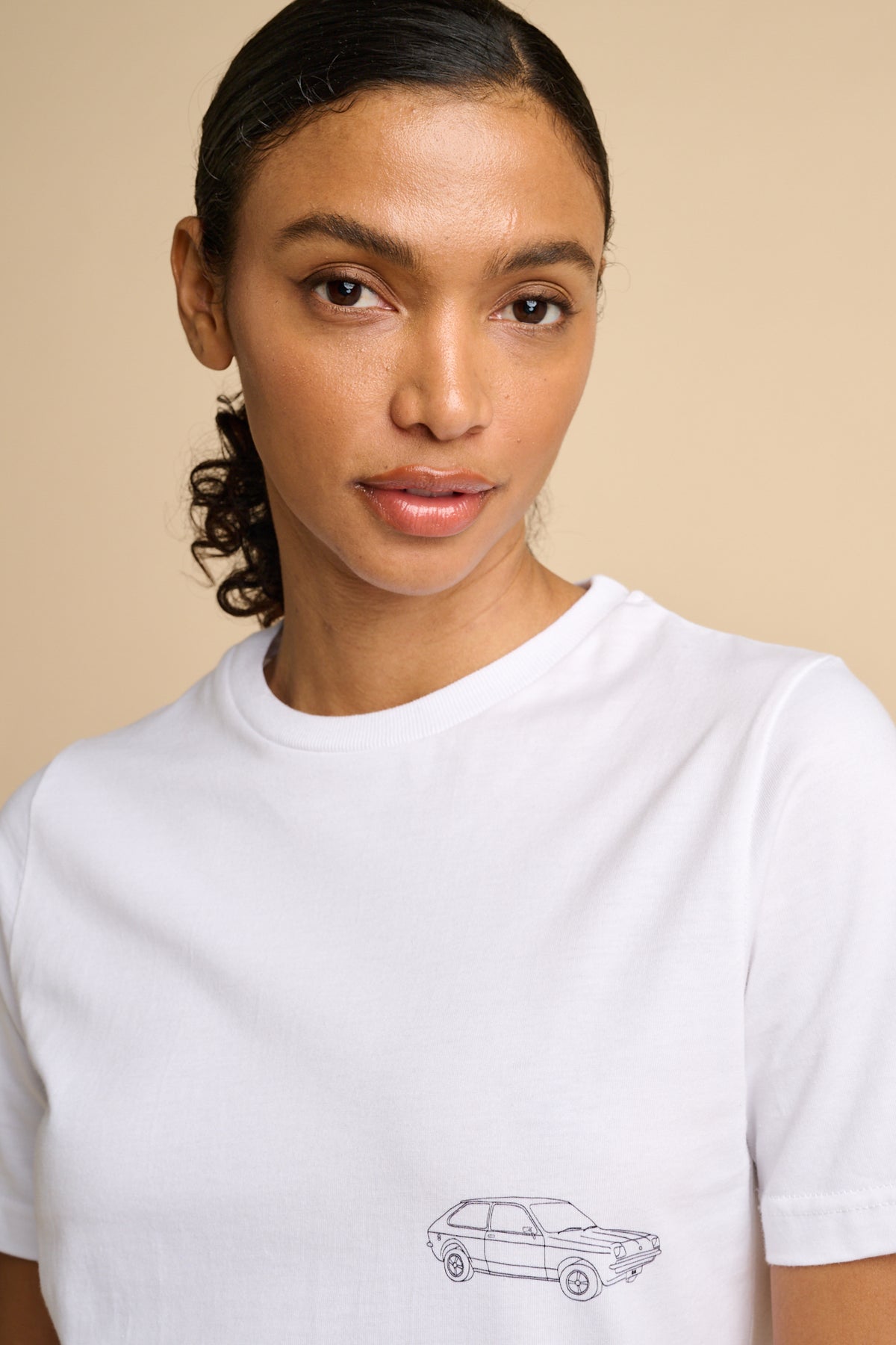 Woman wearing a white t-shirt with a black graphic print.