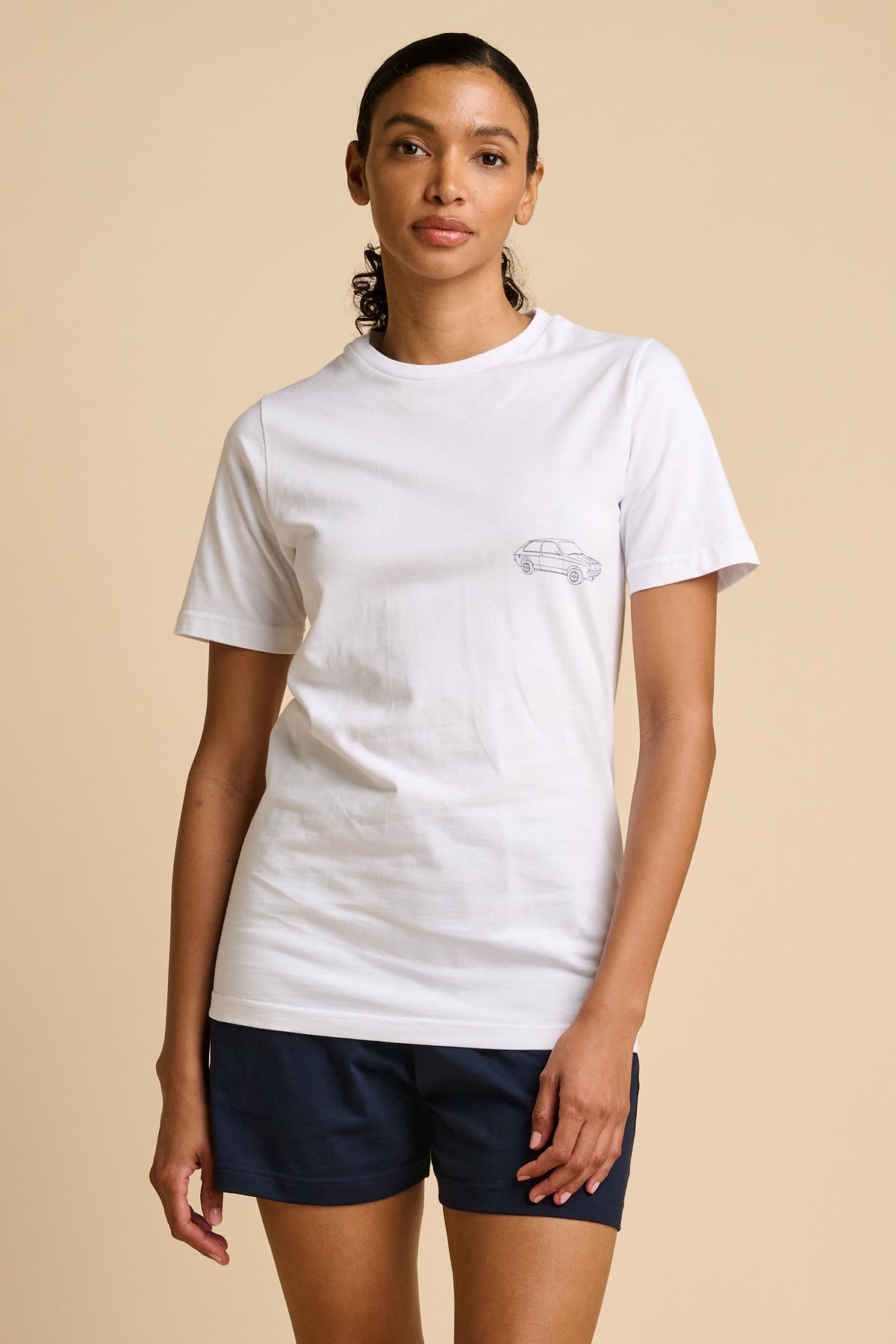 Woman wearing a white t-shirt with a black graphic print.