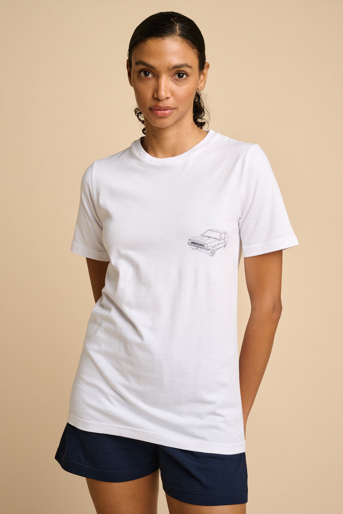 Woman wearing a white t-shirt with a small graphic print.