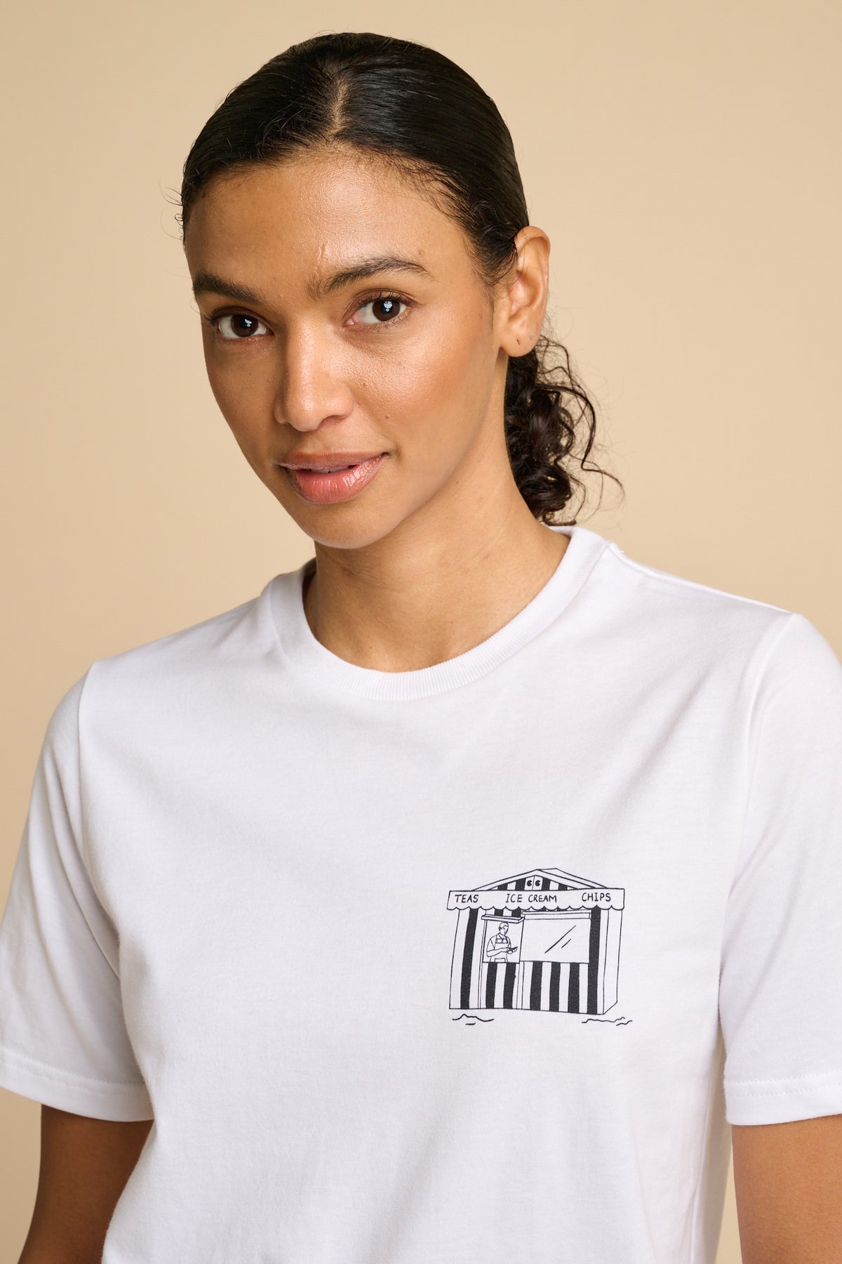 Woman wearing a white t-shirt with a small graphic print.