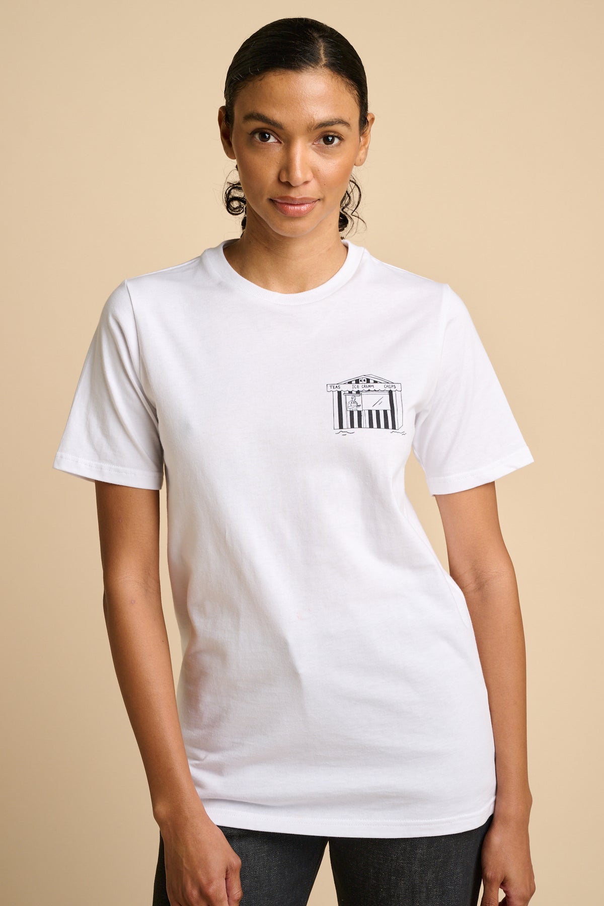Woman wearing a white t-shirt with a small graphic print.
