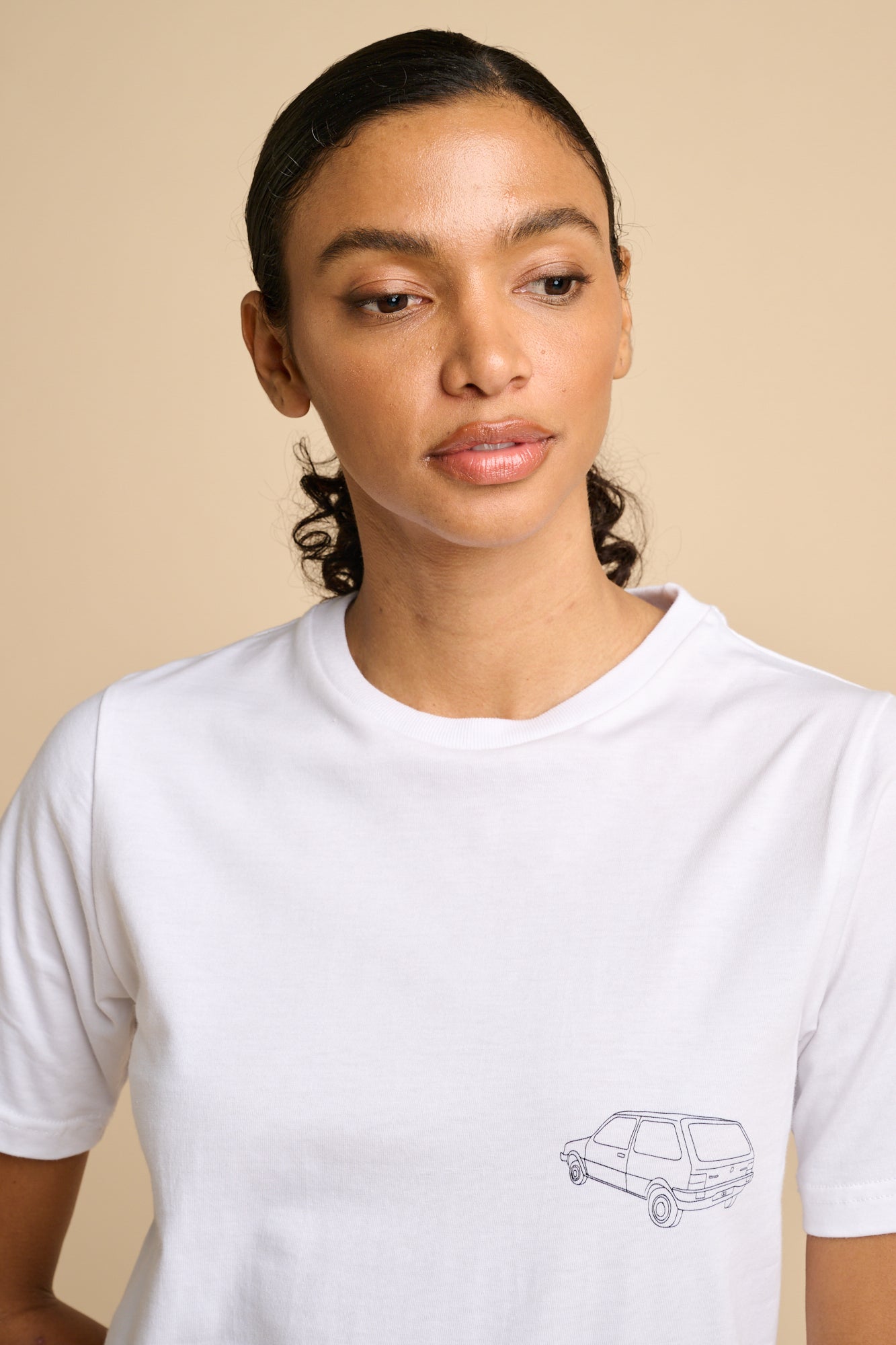 Woman wearing a white t-shirt with a small graphic print.