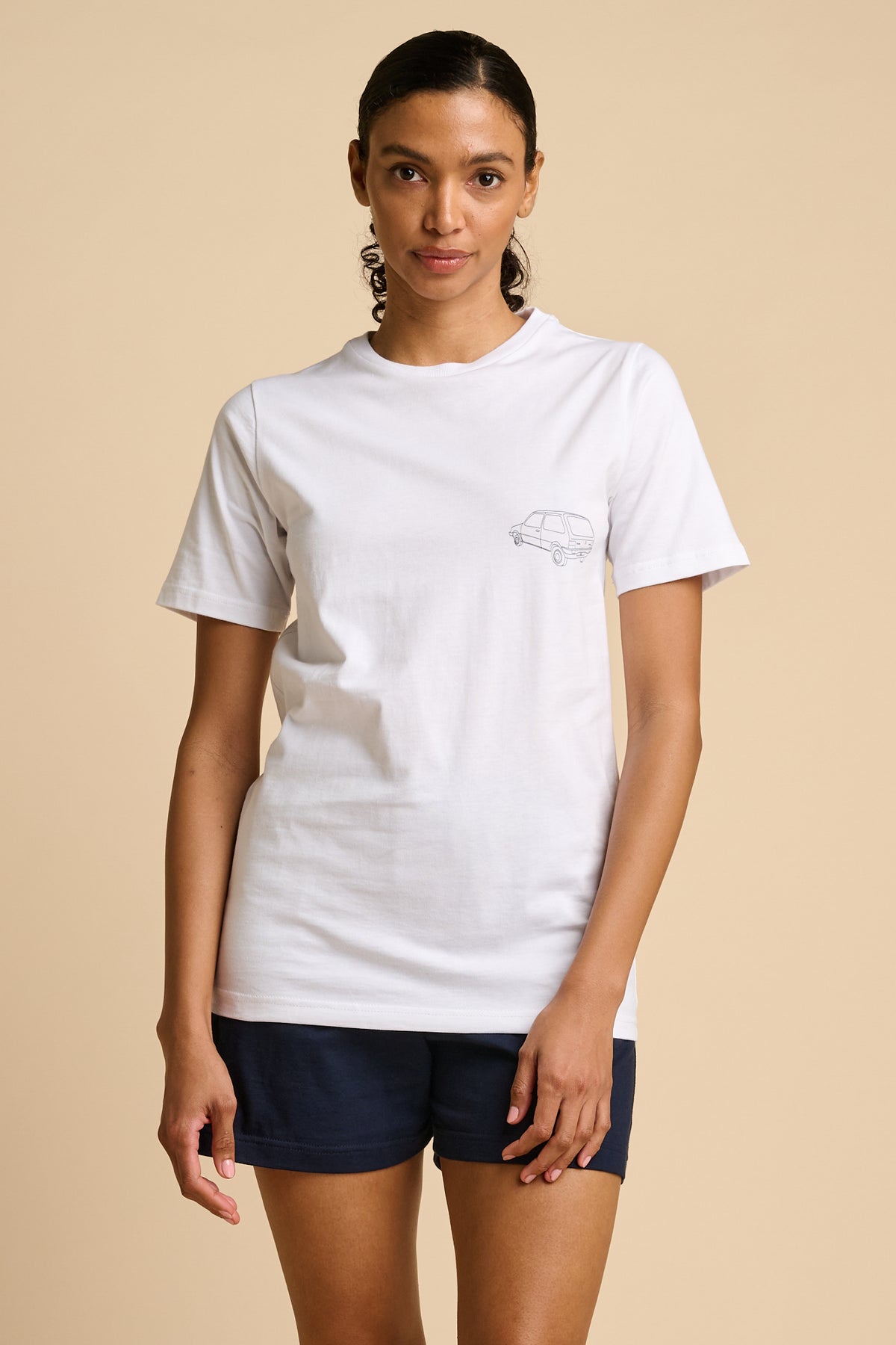 Woman wearing a white t-shirt with a small graphic print.