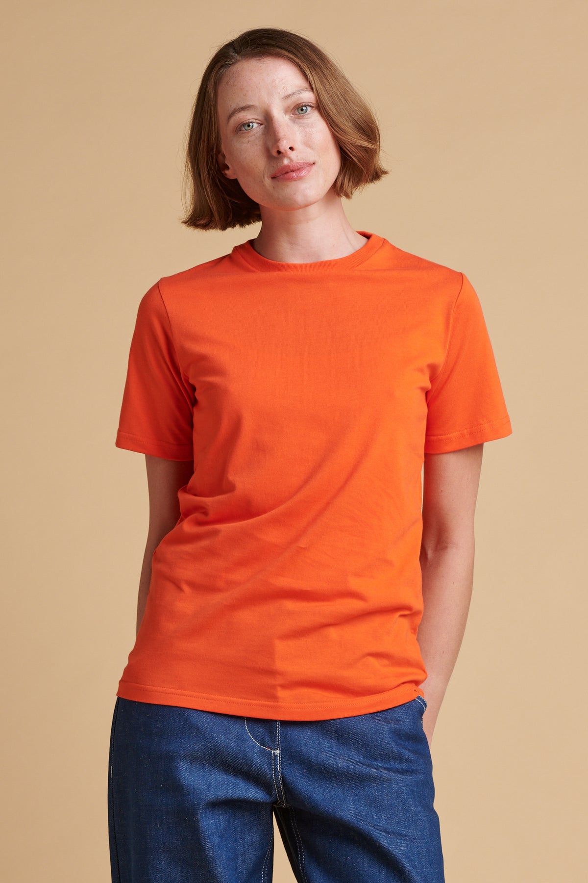 Female wearing short sleeve t shirt in flame red.