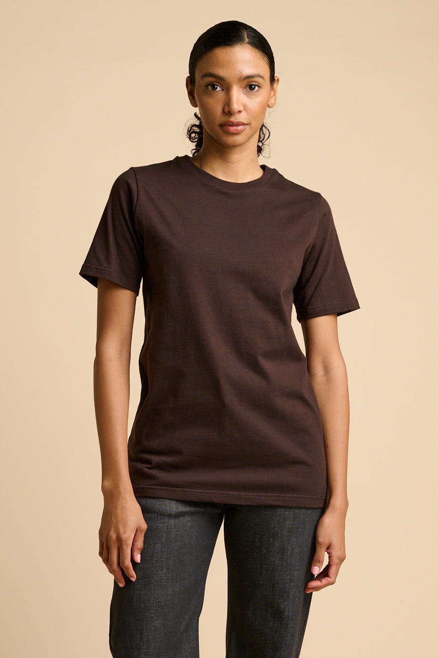 Woman wearing a brown t-shirt against a beige background